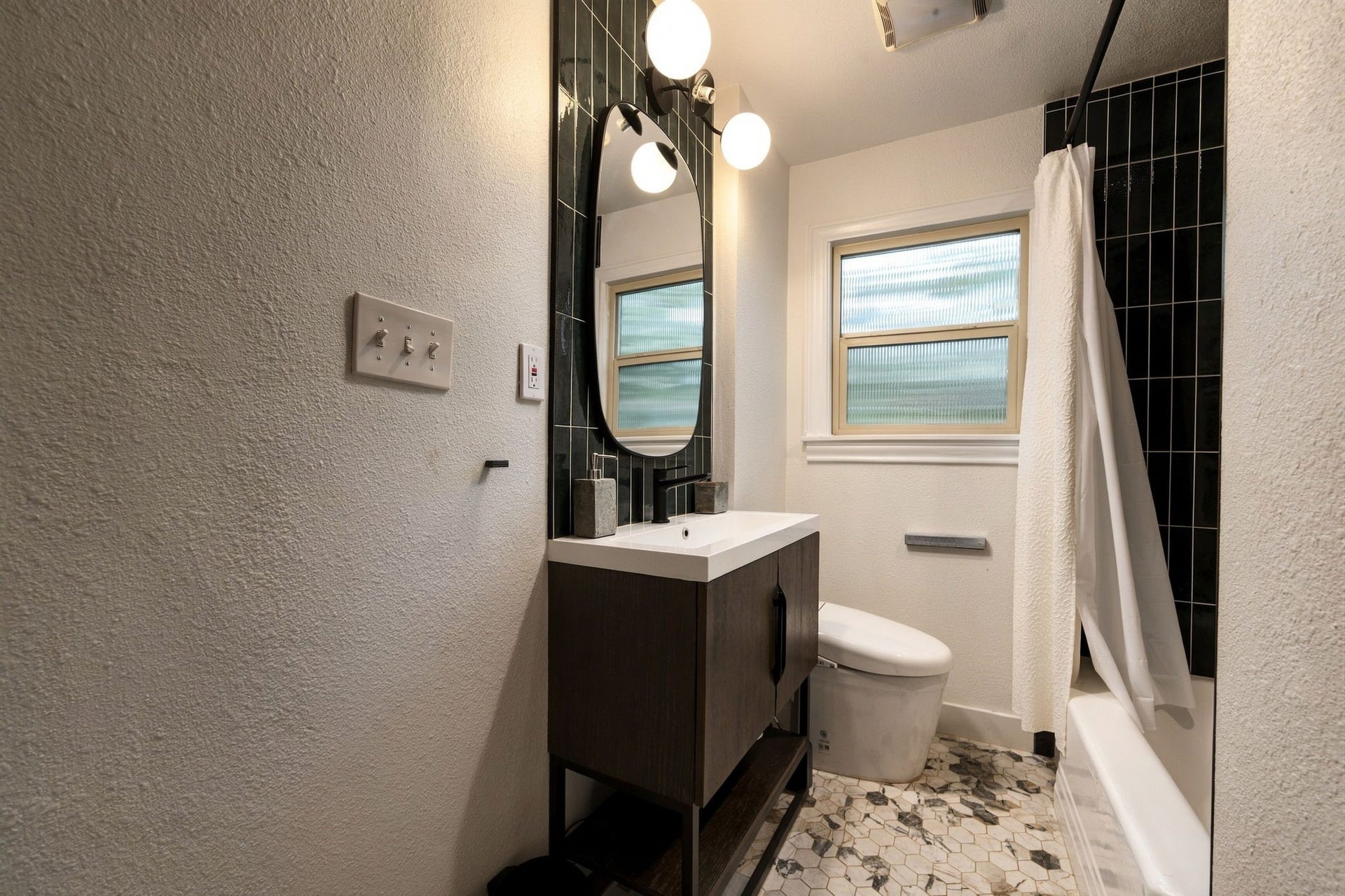 Upstairs bath with smart toilet, tub shower combo and beautiful tile.
