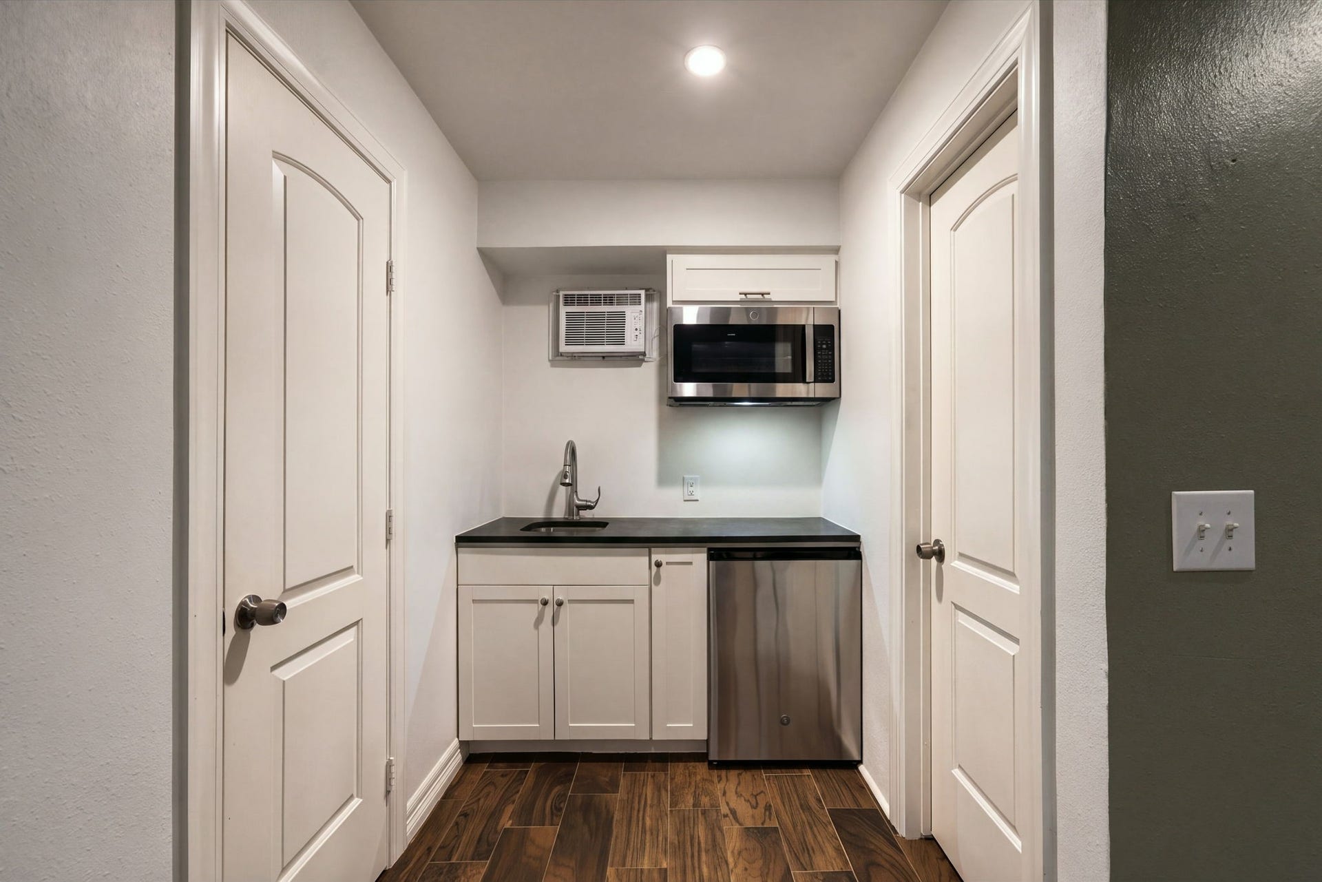 Downstairs kitchenette with sink, fridge and microwave. Closet to the right and full bath to the left.