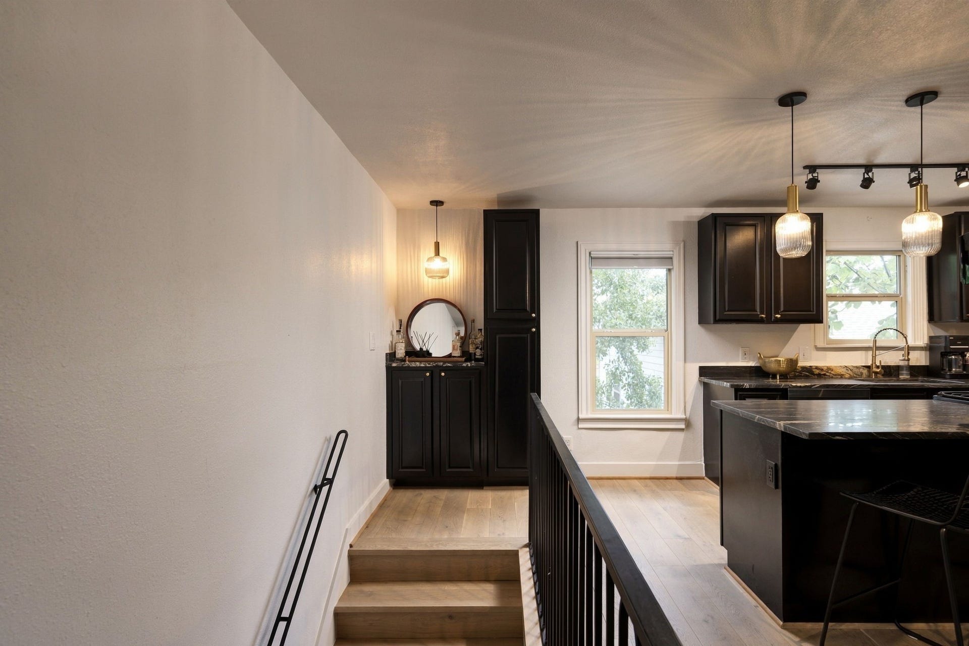 At the top of the stairs is a bar with storage cabinet and the kitchen.