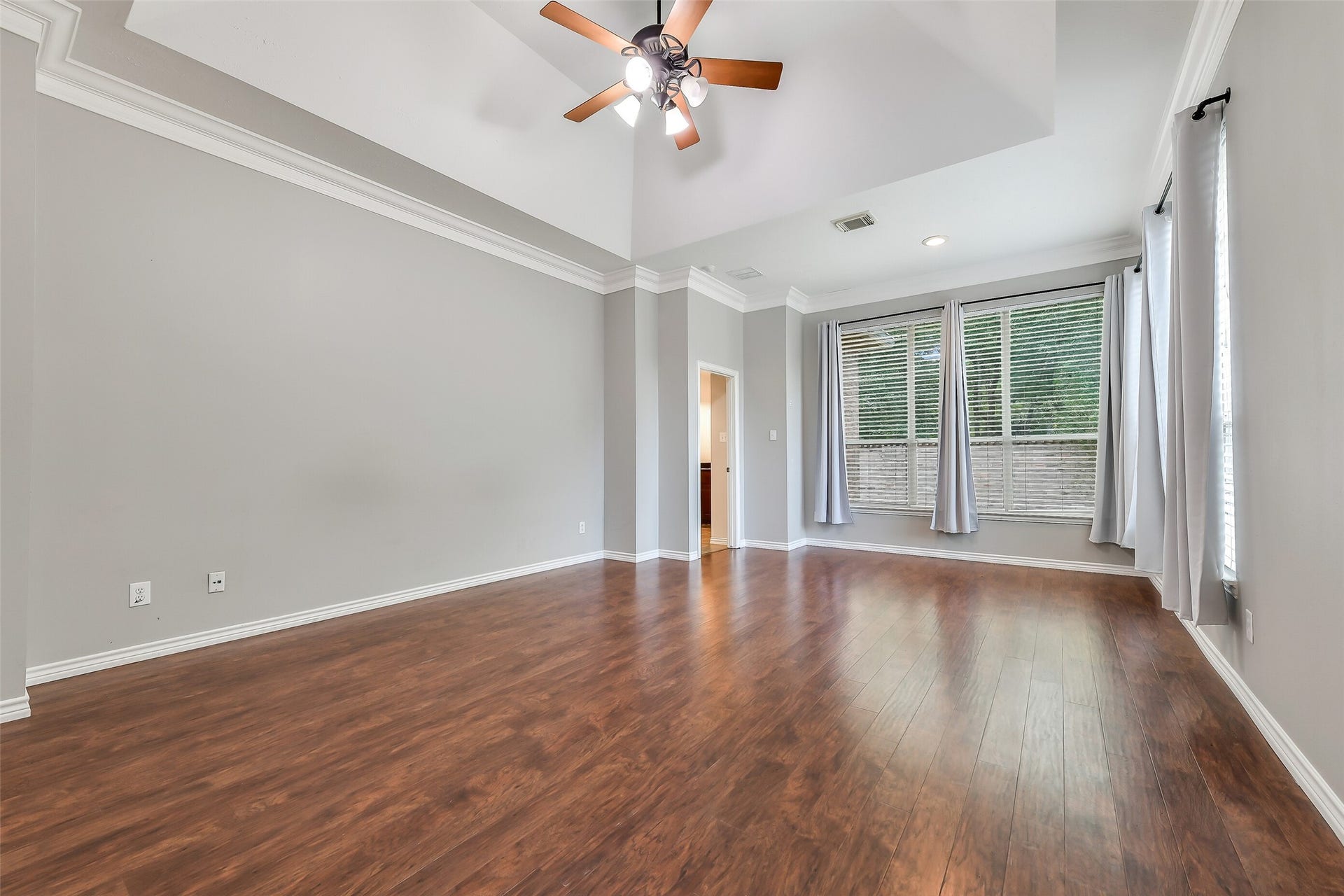 8407 Alyssa Gardens Lane, Humble, TX 77396 The spacious primary bedroom includes a cozy sitting area, vaulted ceiling, double crown molding, floor-to-ceiling windows, custom drapery and en-suite bathroom.