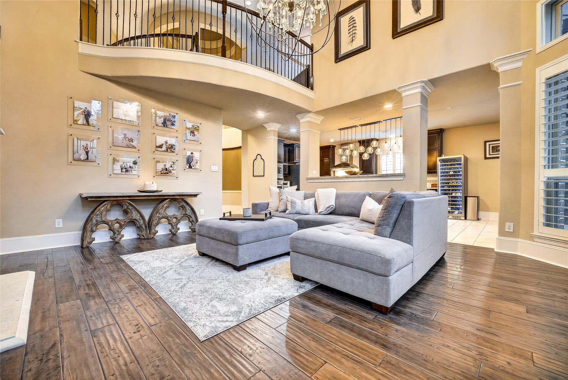 This spacious living room features 2 story high ceilings, and the exposed upstairs catwalk.  An upstairs balcony overlooks the space, enhancing the room's grandeur.
