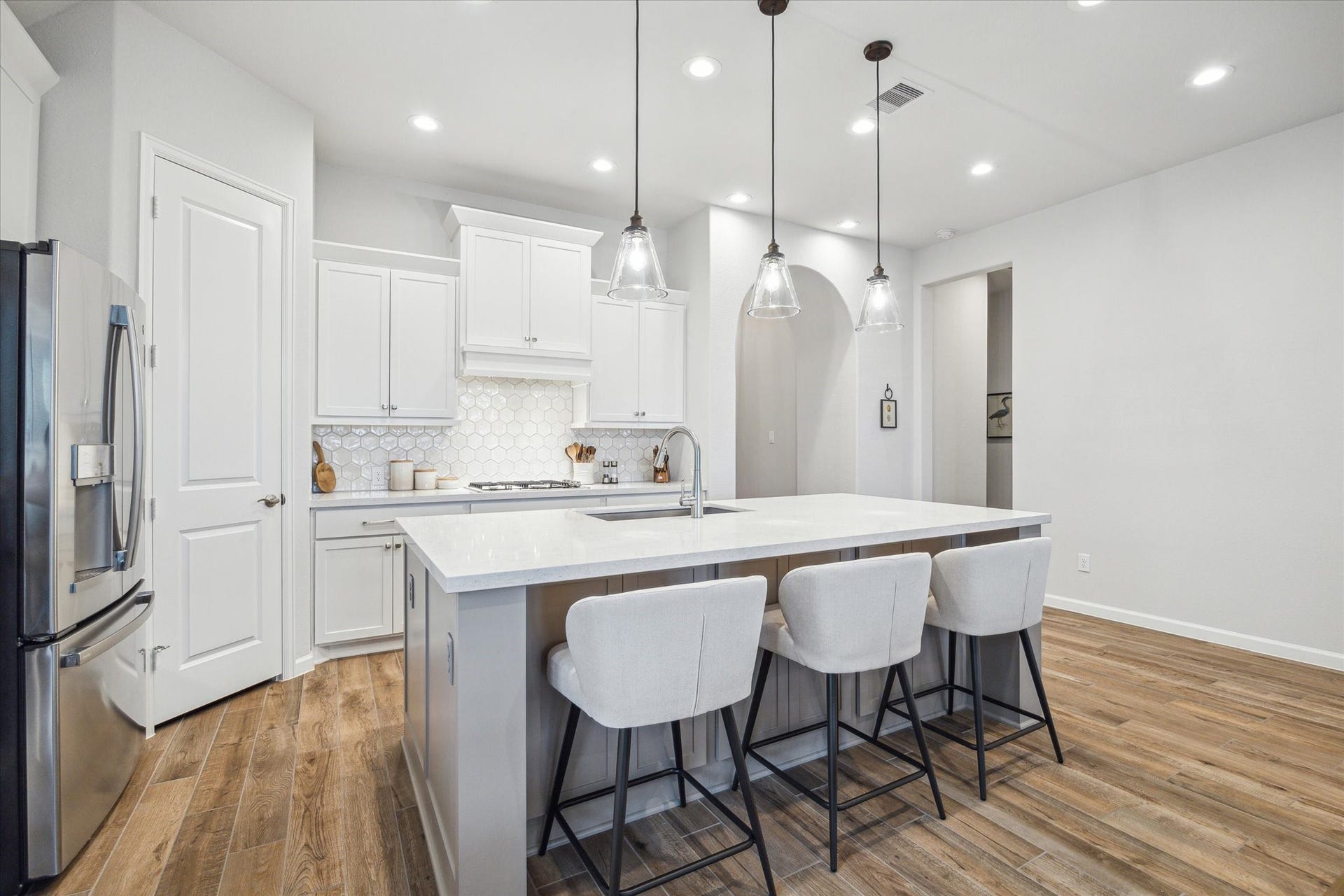 1523 Carson Field Lane, Richmond, TX 77469 The Kitchen Island offers Breakfast Bar seating & features additional storage. Utility Room is beyond the corridor to the right.