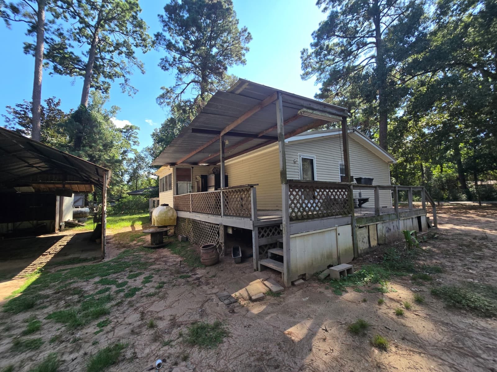 Charming home with a spacious covered deck, nestled among tall trees for a serene, natural setting. Perfect for enjoying the outdoors.