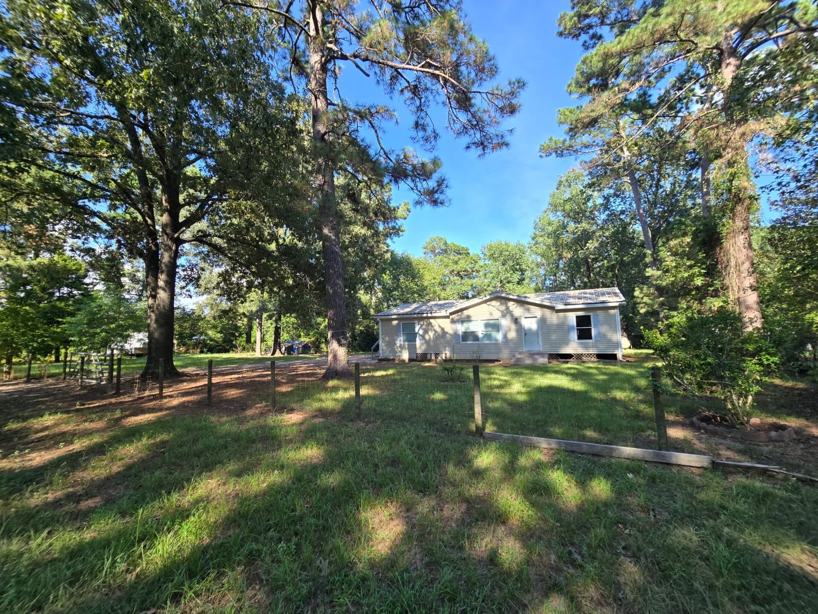 Charming home nestled among mature trees, offering a serene and private setting with a spacious yard ideal for outdoor enjoyment.