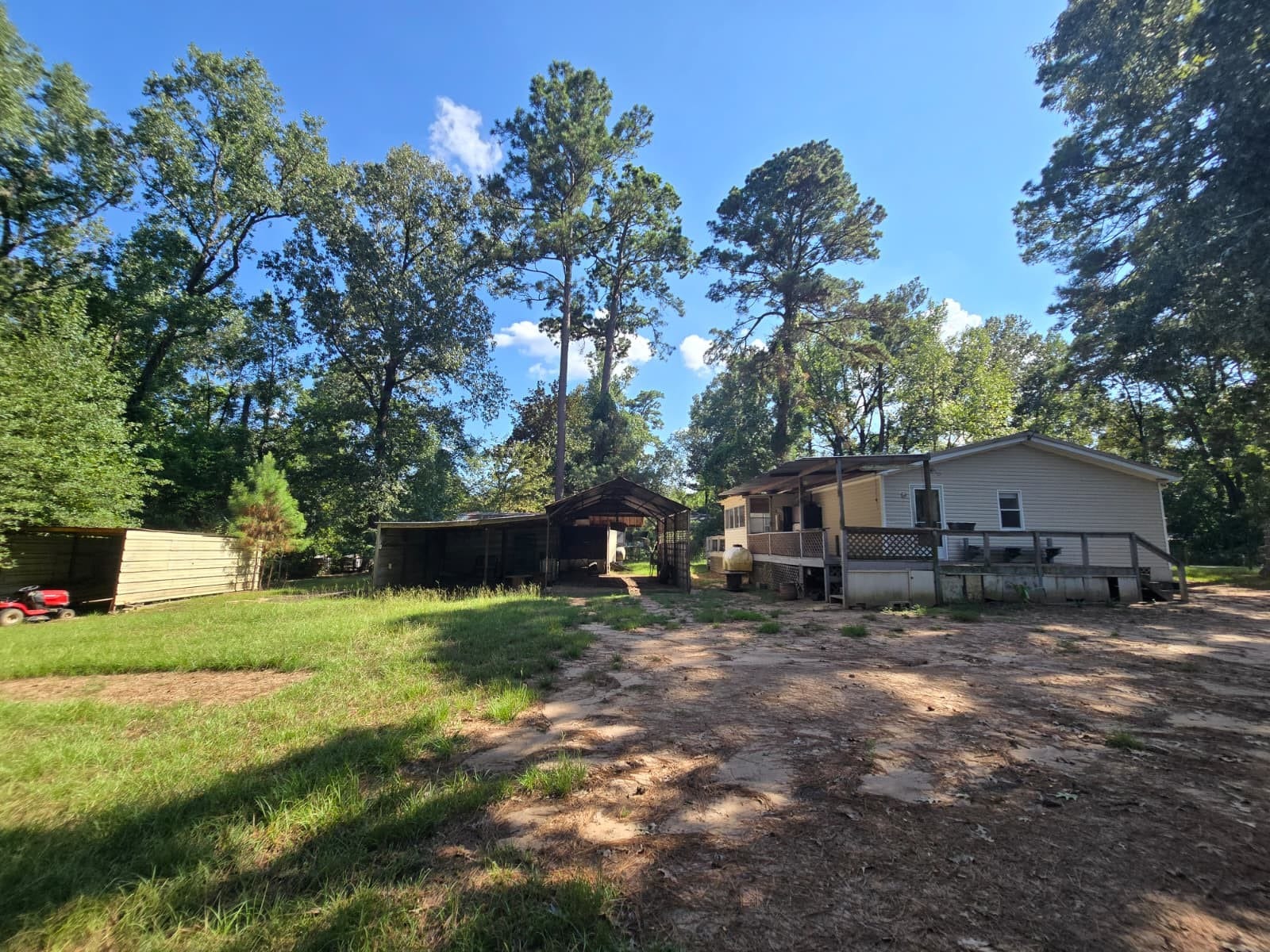 Charming countryside retreat with a spacious mobile home, surrounded by lush greenery and mature trees. Ample outdoor space for relaxation and recreation, complete with a covered area and additional storage.