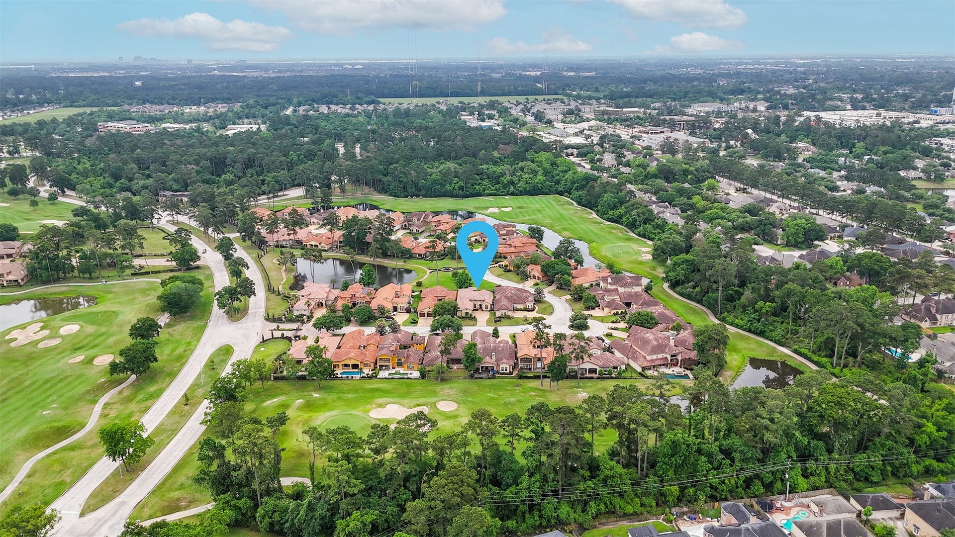This aerial photo showcases a beautiful suburban neighborhood surrounded by lush greenery and a golf course. The homes feature stylish architecture with tiled roofs, and the area is dotted with trees and small ponds, offering a serene and upscale living environment.