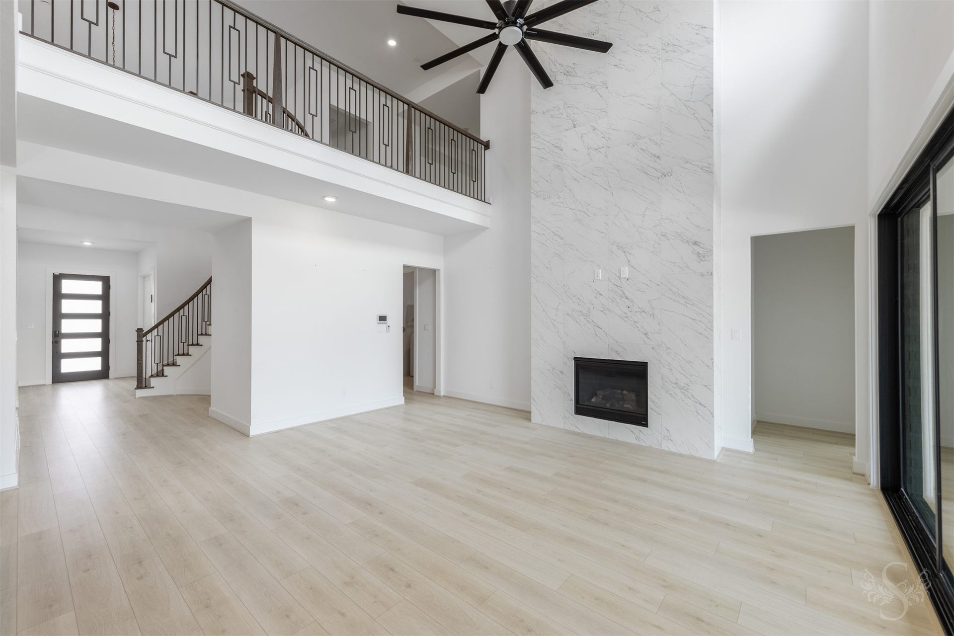 Spacious living room with fireplace and abundant natural light.