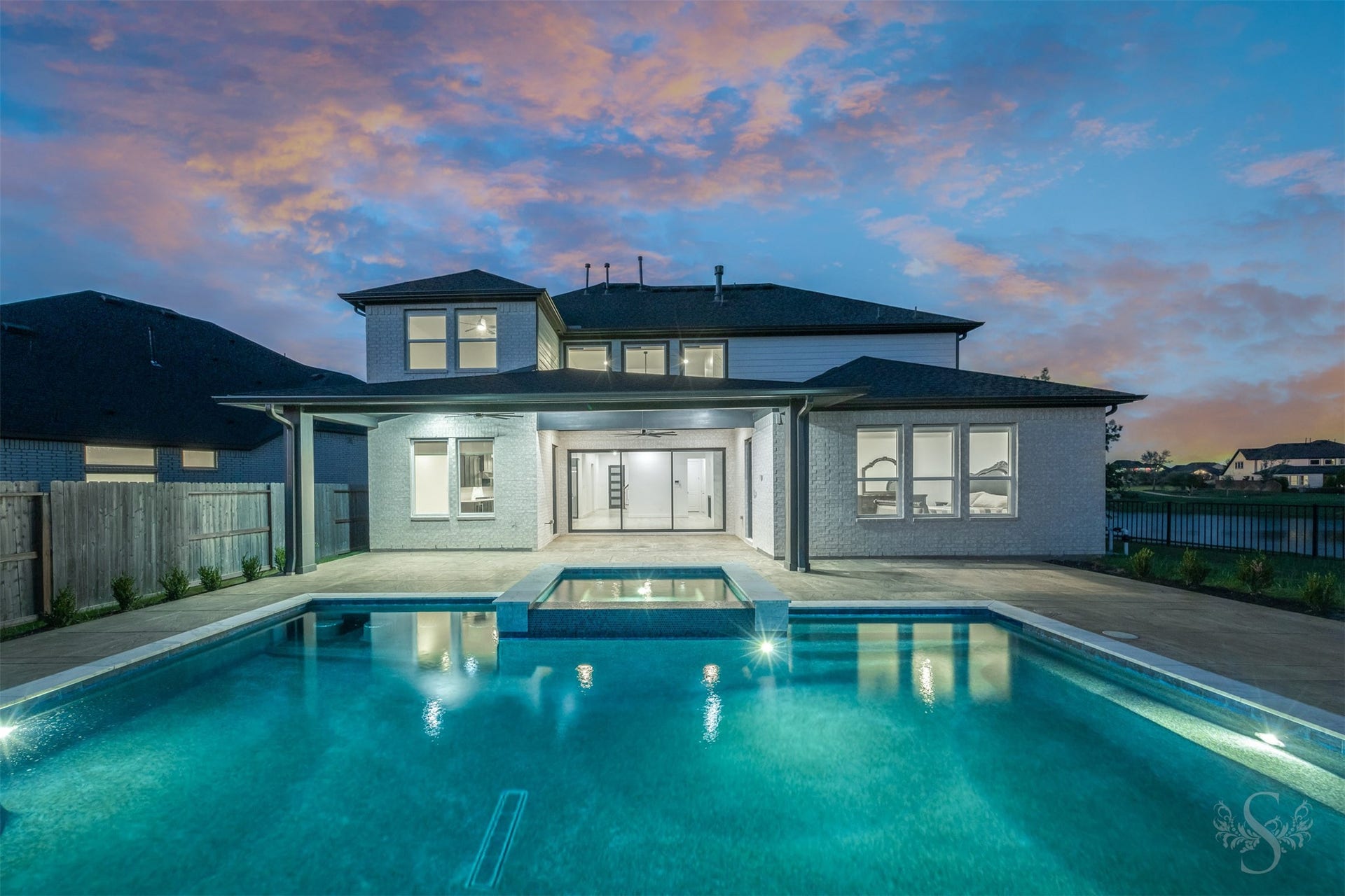 Resort-style pool beautifully illuminated at sunset.
