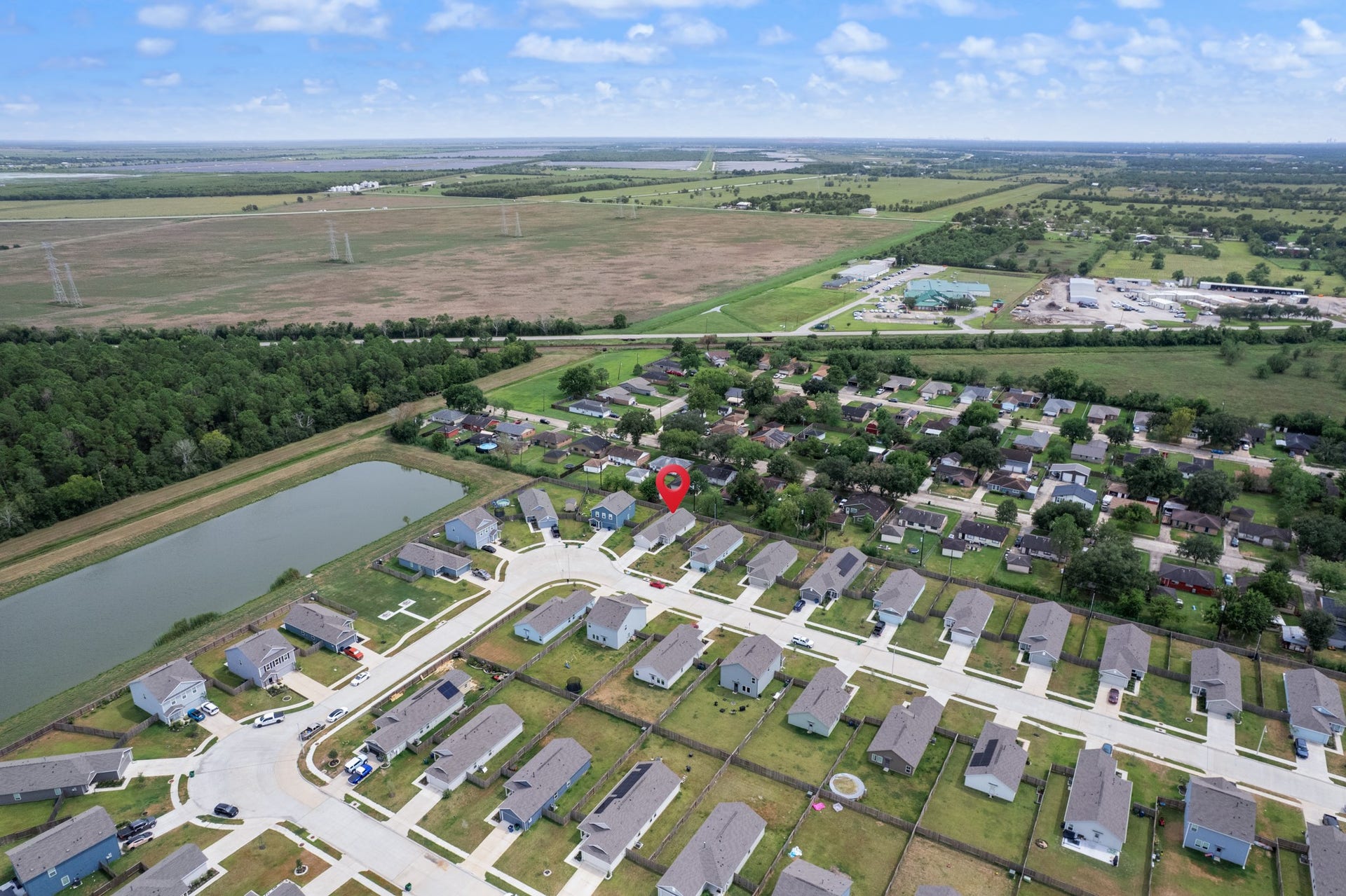 Expansive aerial view highlights the propertys position within the neighborhood and the mix of residential and open surroundings.