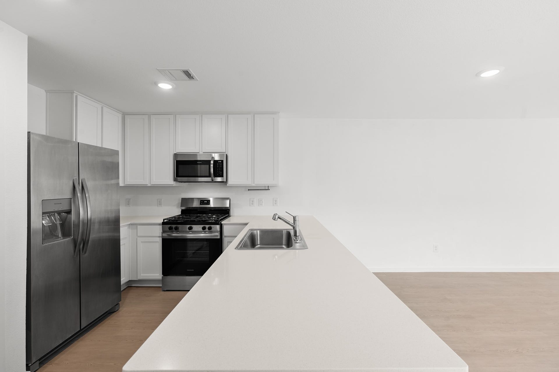 Generous peninsula offers abundant countertop space along with an integrated sink and dishwasher. Stainless steel appliances and plentiful cabinetry complete the functional kitchen layout.