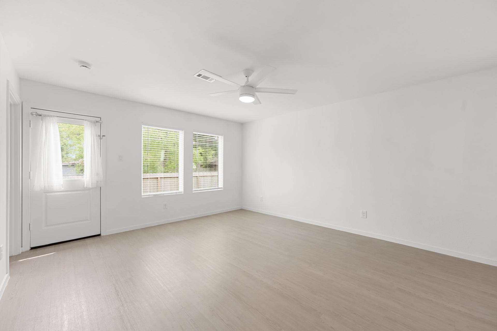 Alternate view highlights the living rooms open footprint, abundant natural light, and generous wall space for flexible furniture arrangements.