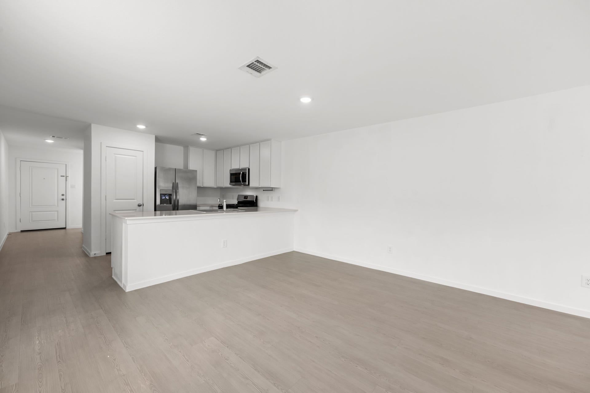 Bright dining space provides a natural transition between the kitchen and living room, complemented by continuous flooring and recessed lighting.