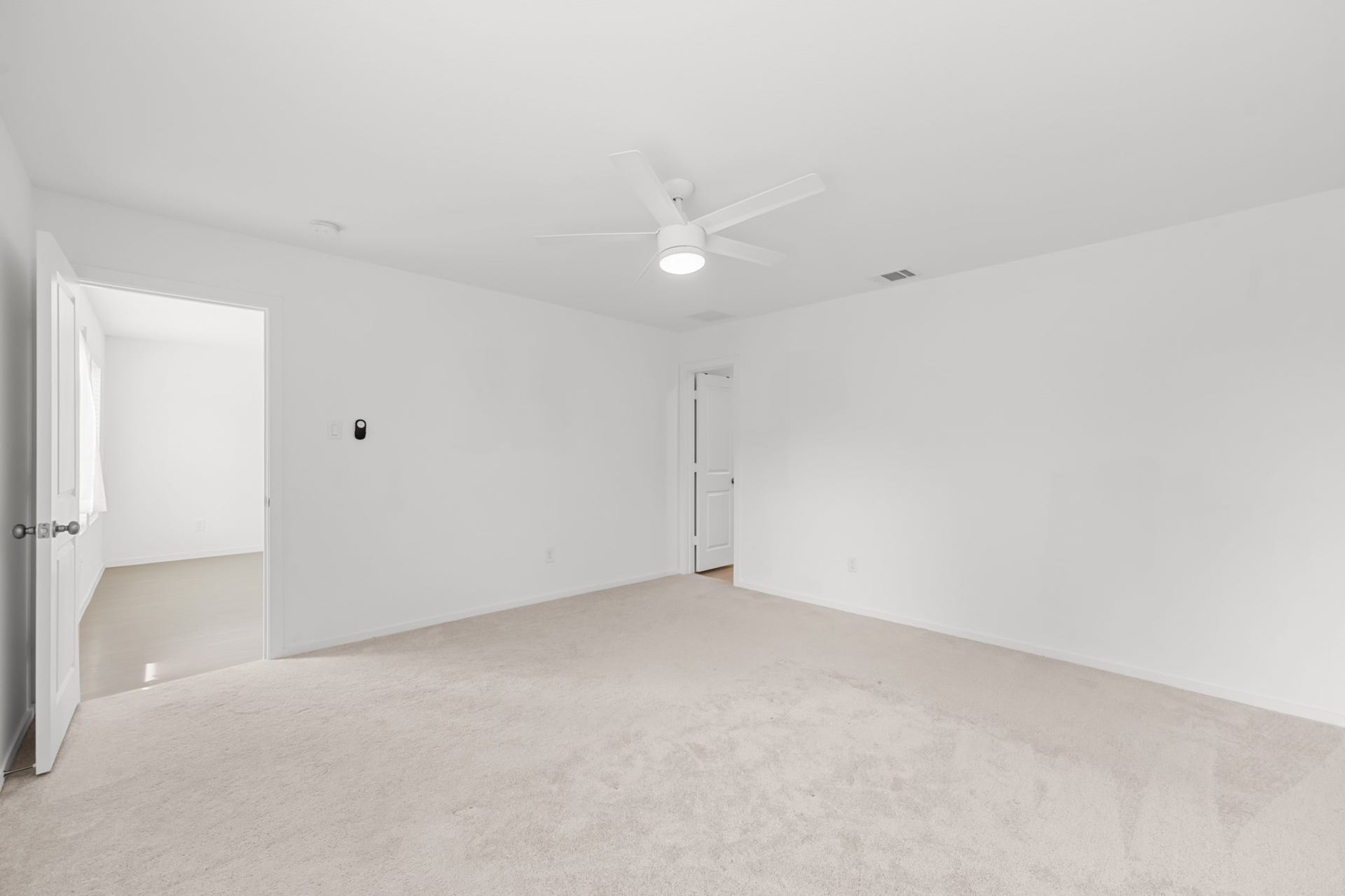 Additional view of the primary bedroom showcases its generous proportions and direct connection to the adjoining spaces.