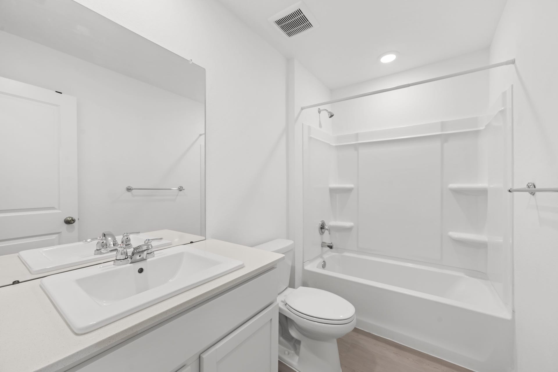 Bathroom features a spacious vanity, large wall mirror, and tub/shower combination with built-in shelving.