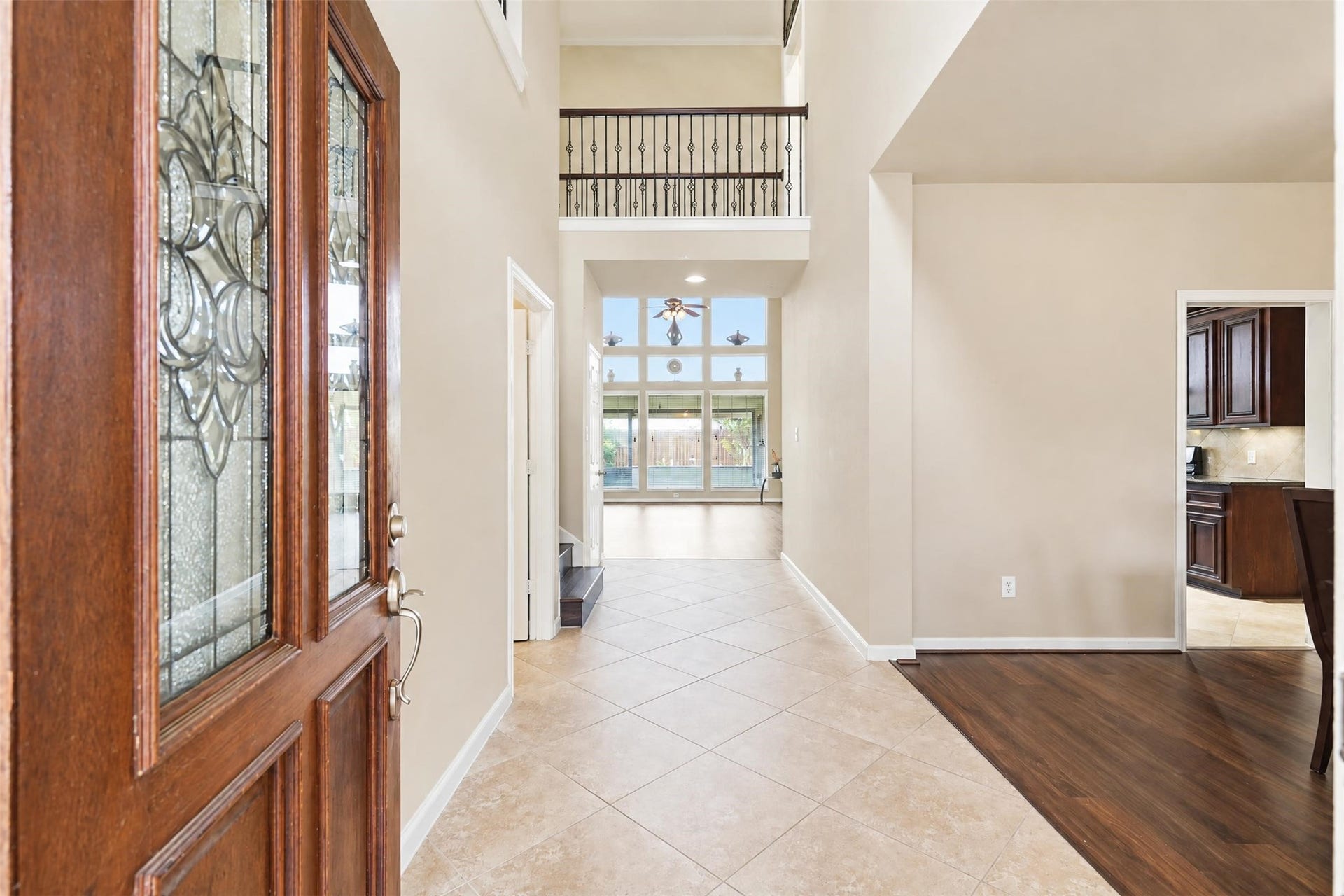 5106 Autumn Rose Lane, Sugar Land, TX 77479 Step inside to a bright two-story entry with a leaded-glass front door, updated flooring and a clear sightline to the soaring wall of windows in the living room.