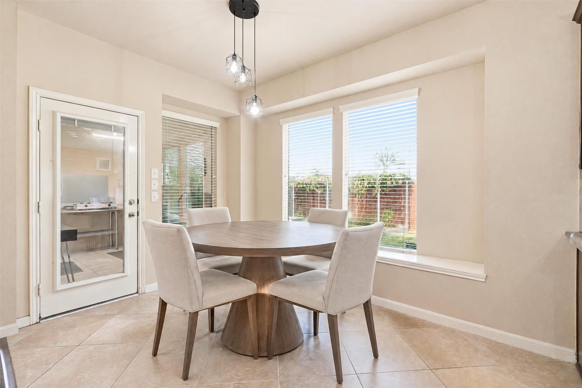 5106 Autumn Rose Lane, Sugar Land, TX 77479 Virtually staged. A sunny breakfast nook with backyard views and a door straight into the enclosed spice kitchen. A bright, easy spot for morning coffee.
