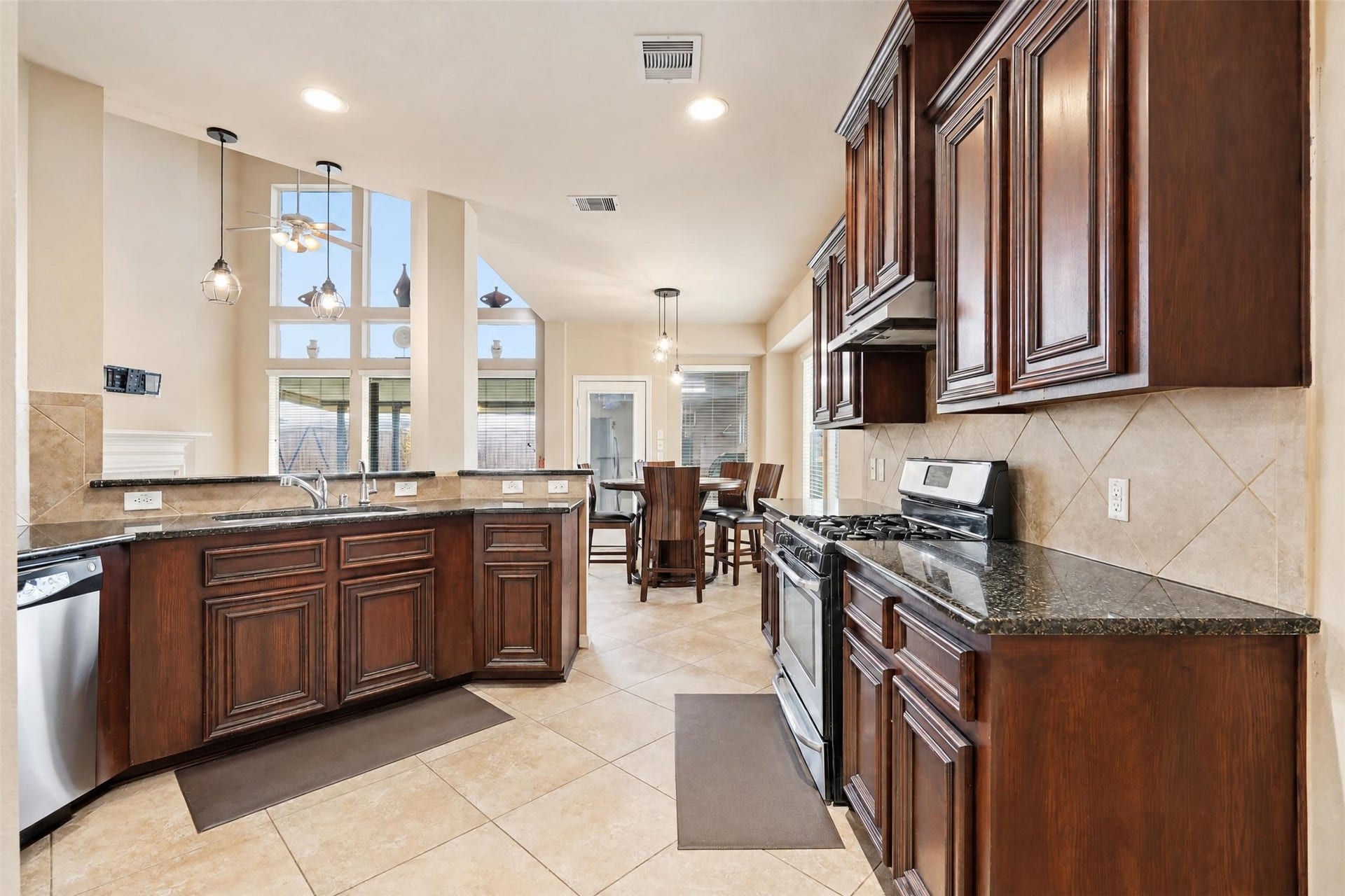 5106 Autumn Rose Lane, Sugar Land, TX 77479 The kitchen is set up for real cooking: rich wood cabinetry, granite counters, stainless appliances and a gas range, all open to the breakfast area and living room so the cook is never left out.