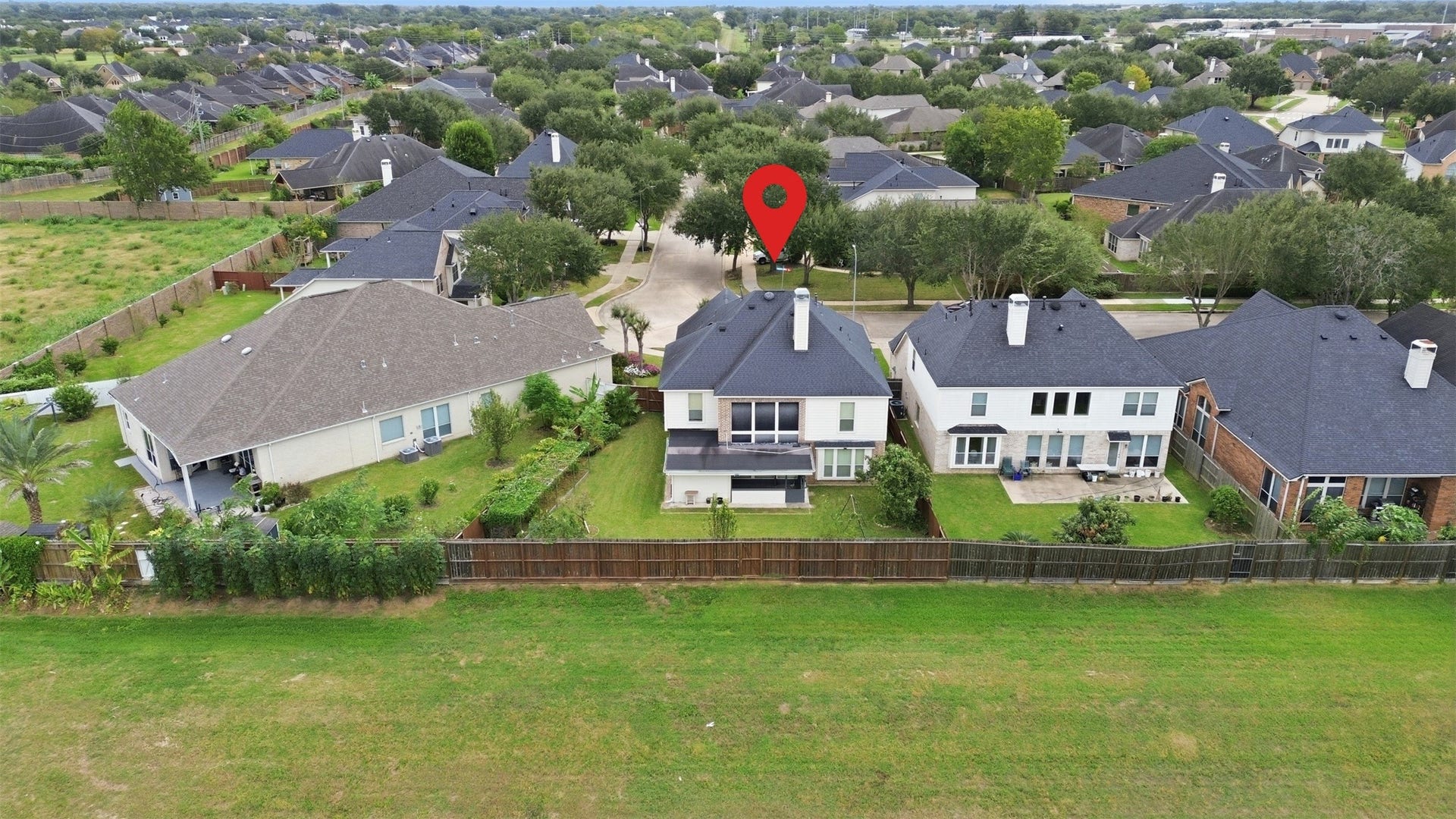 5106 Autumn Rose Lane, Sugar Land, TX 77479 From behind the home you can see what makes this lot special: open green space instead of a neighbors backyard, with mature trees lining the quiet streets of Riverstone.