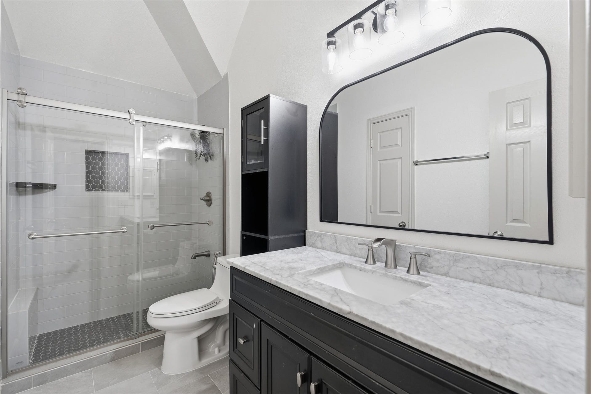 5106 Autumn Rose Lane, Sugar Land, TX 77479 Updated bathroom with marble-look counters, a matte black vanity, a statement mirror and a glass-enclosed shower.