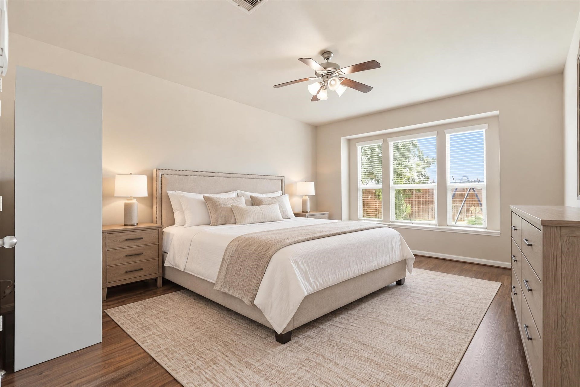 5106 Autumn Rose Lane, Sugar Land, TX 77479 Virtually staged. The primary suite is on the main floor and set apart from the upstairs bedrooms for privacy, with about 13'8" x 16'11" of space for a king bed and a sitting area.