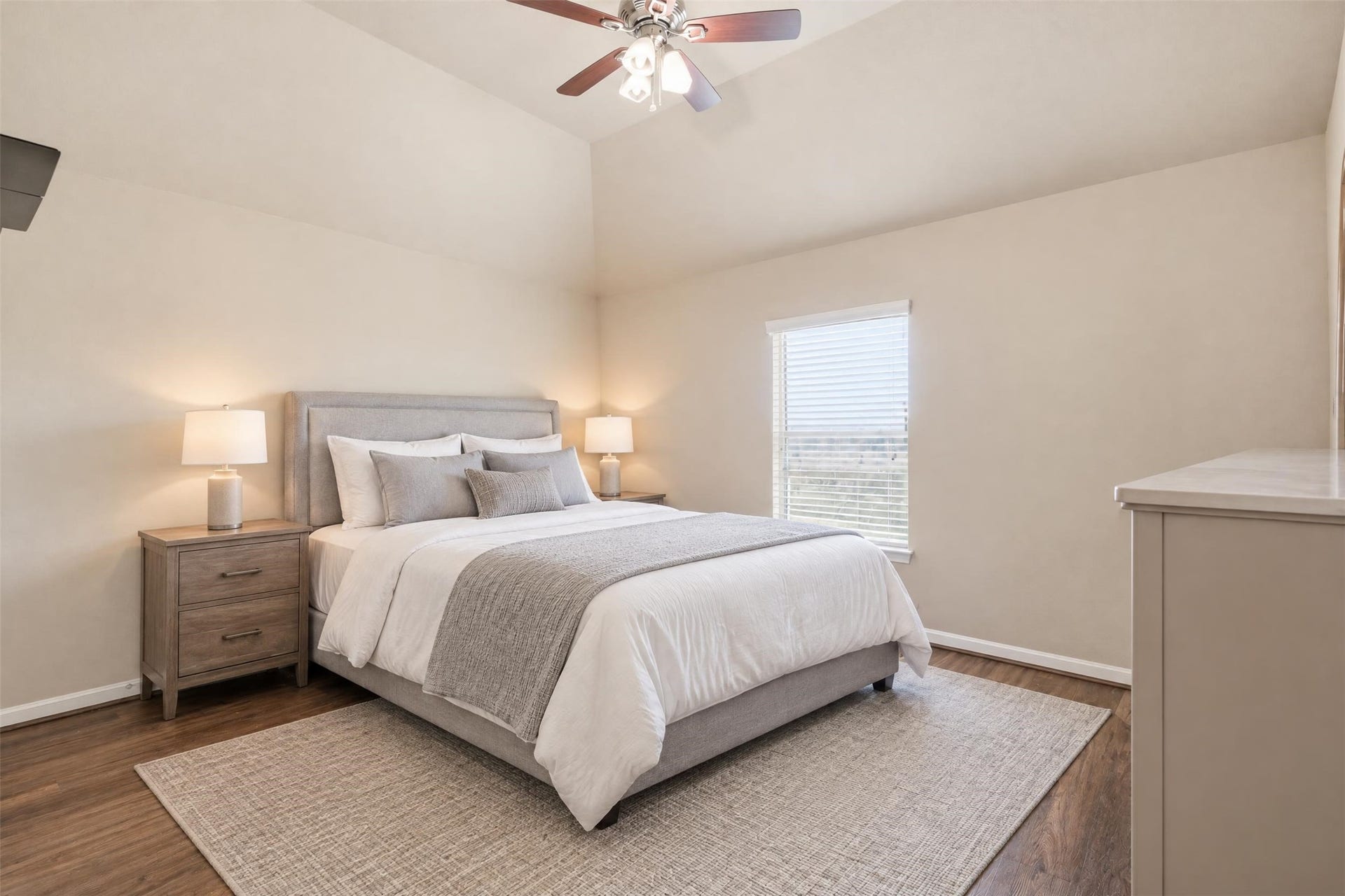 5106 Autumn Rose Lane, Sugar Land, TX 77479 Virtually staged. Secondary bedroom with a vaulted ceiling and lots of natural light, with room for a queen bed and a desk.