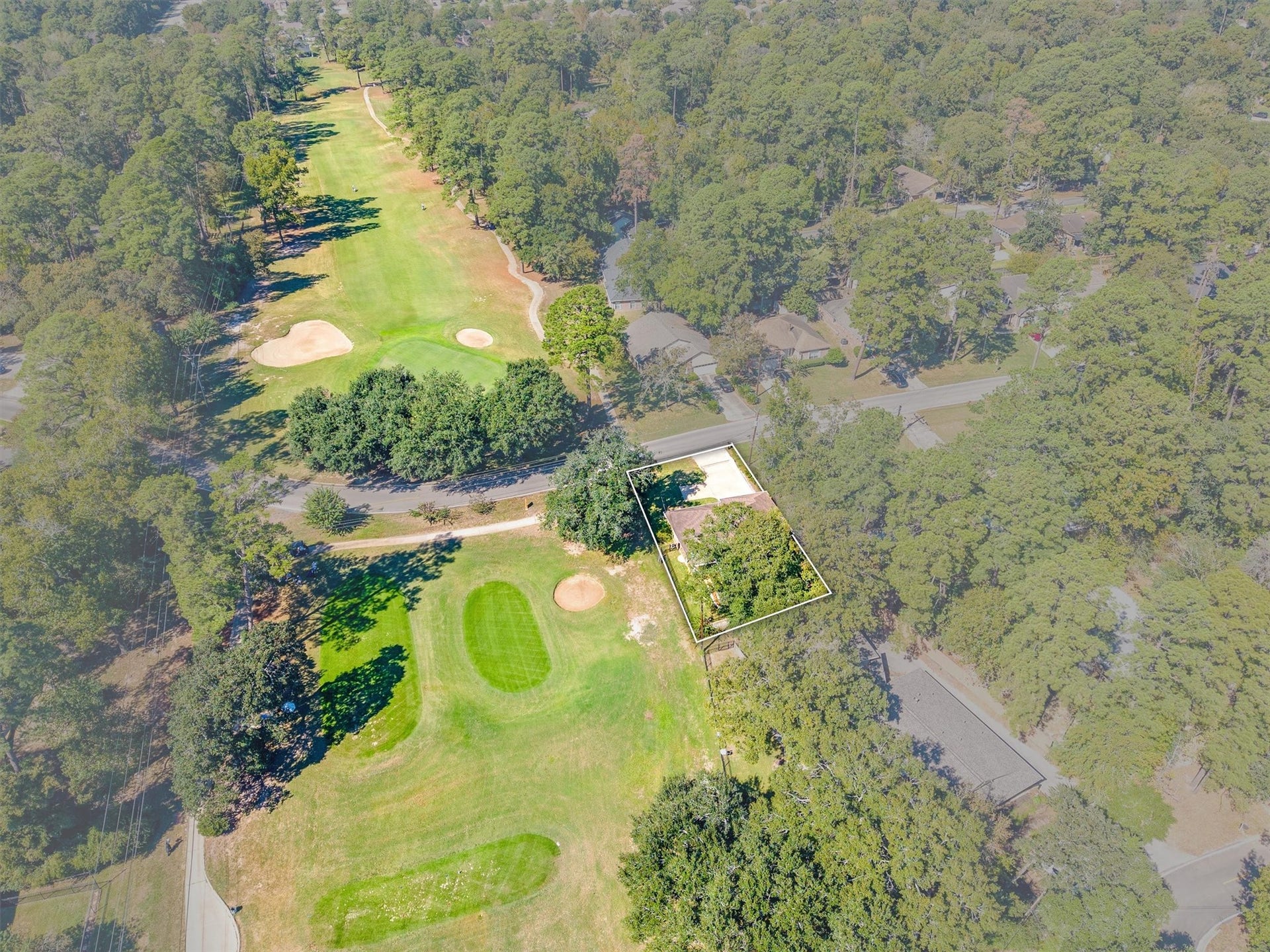 149 Thunderbird Drive, Conroe, TX 77304 And THERE it is: the 16th tee box sits right next door, with the fairway stretching out toward the green, giving you a front-row seat to every round played here.