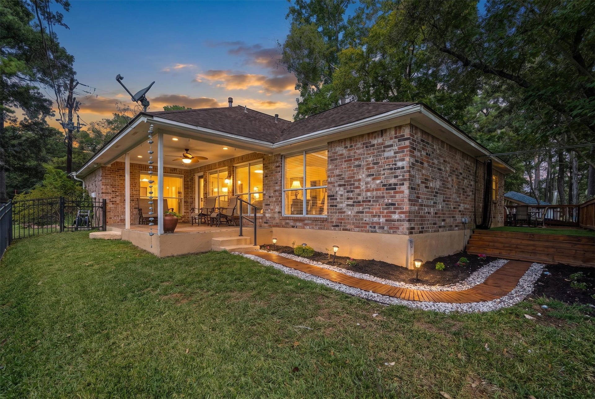 149 Thunderbird Drive, Conroe, TX 77304 As the sun goes down, the covered patio glows and the path lights come on, setting the scene for slow evenings out back.