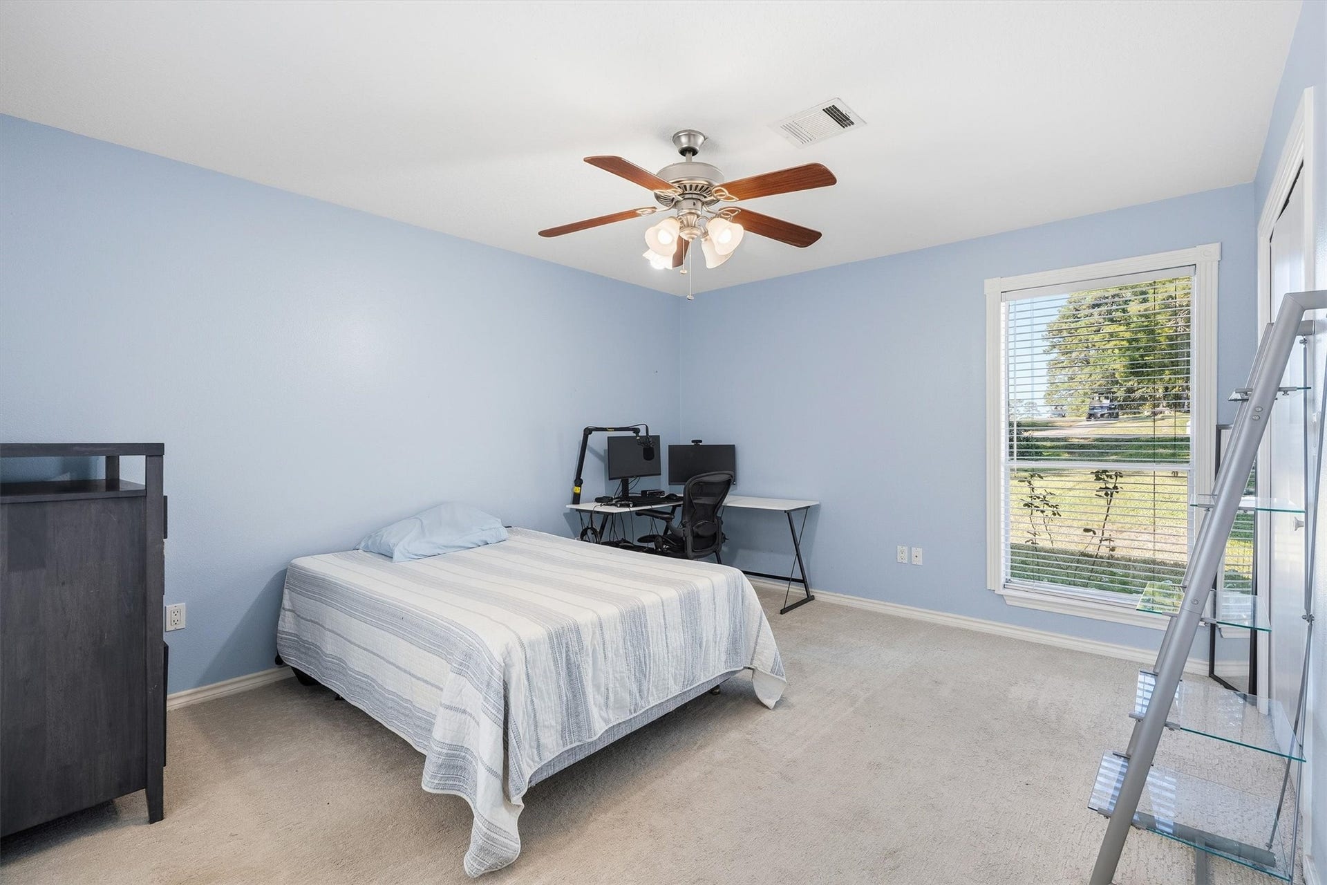 149 Thunderbird Drive, Conroe, TX 77304 Designed for comfort, this secondary bedroom offers soft carpet, a ceiling fan, and plenty of room for a desk setup alongside the bed.