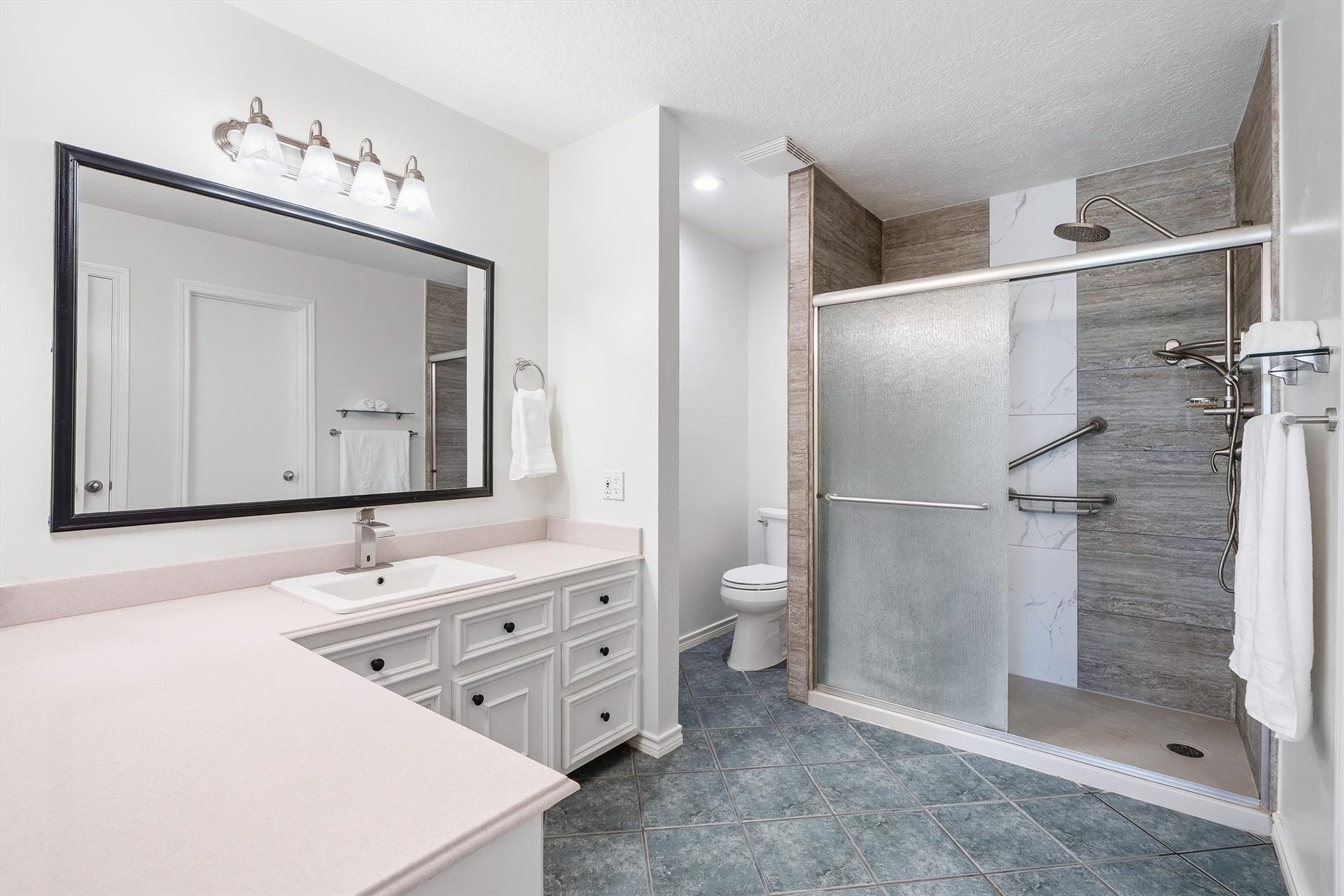 149 Thunderbird Drive, Conroe, TX 77304 The extra-large walk-in shower steals the show here, with frosted shower door, finished with built-in grab bars and a rainfall showerhead for a spa-style routine every morning.