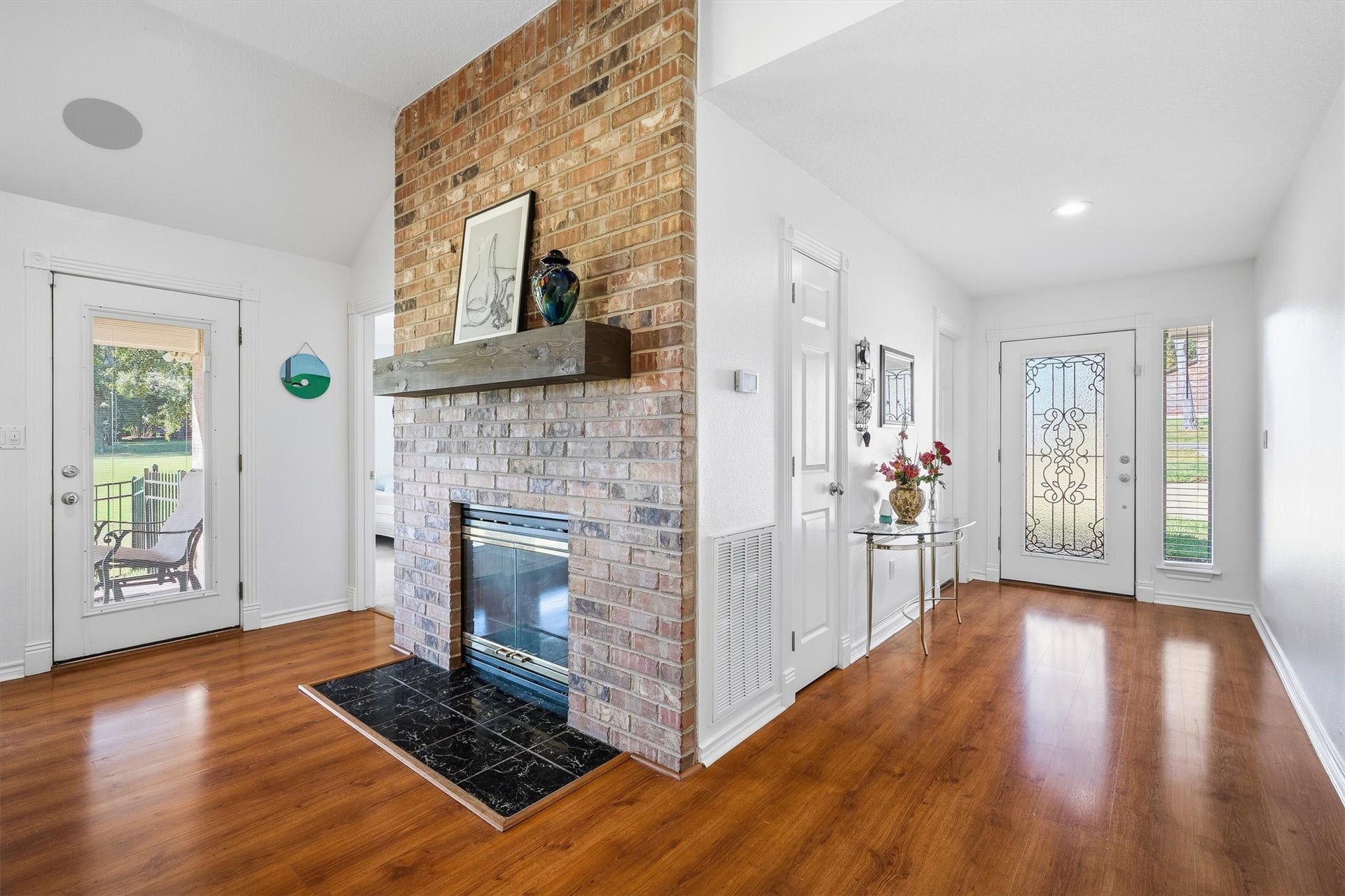 149 Thunderbird Drive, Conroe, TX 77304 A floor-to-ceiling brick fireplace with a rustic wood mantel anchors the room, ready for cozy nights whenever a Texas cold front decides to show up.