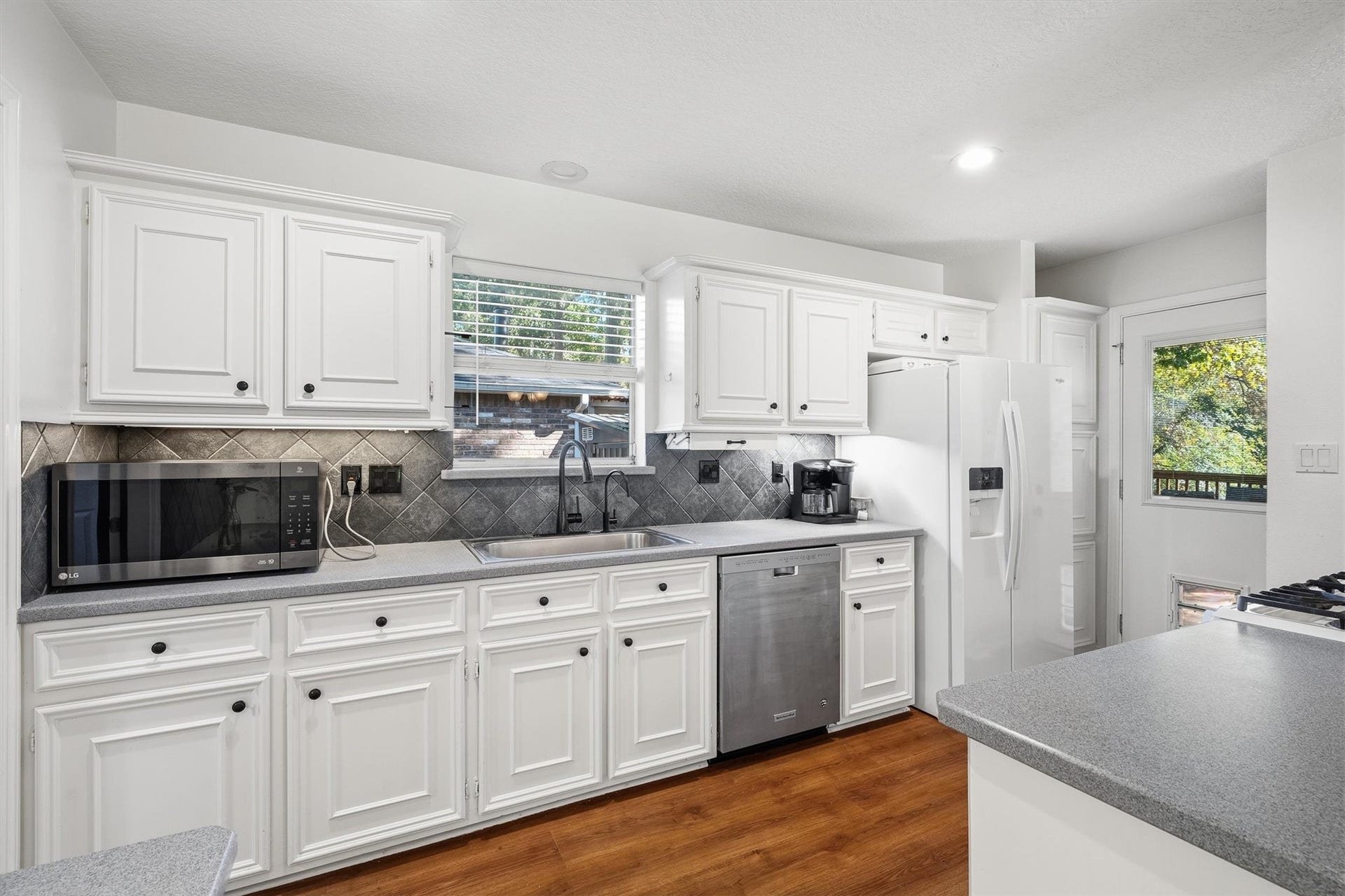149 Thunderbird Drive, Conroe, TX 77304 Under-cabinet lighting keeps the counters bright for early-morning coffee and late-night snacks, while the window over the sink brings in a little daylight too.