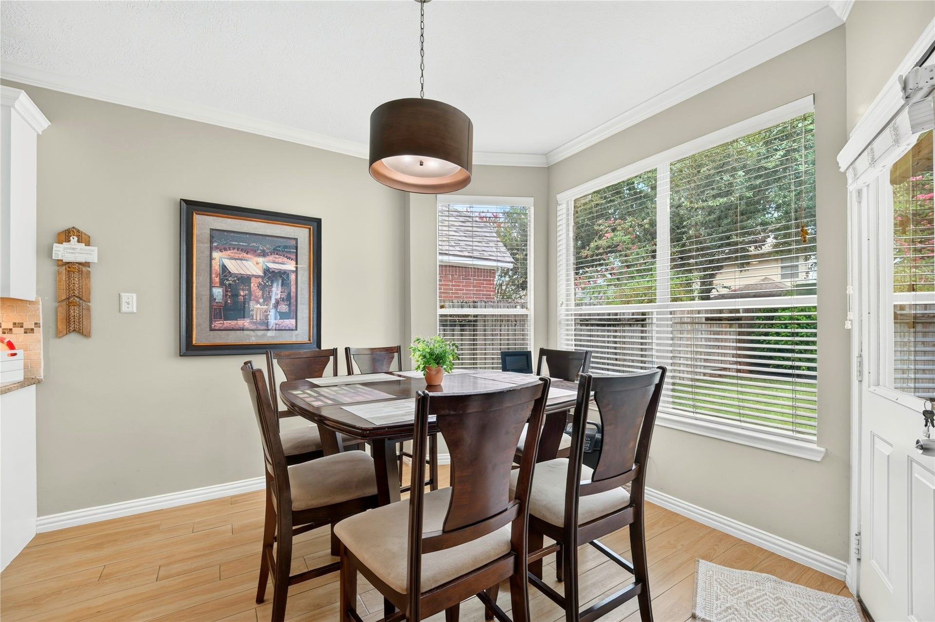 Bright breakfast area surrounded by large windows, offering abundant natural light and beautiful backyard views.