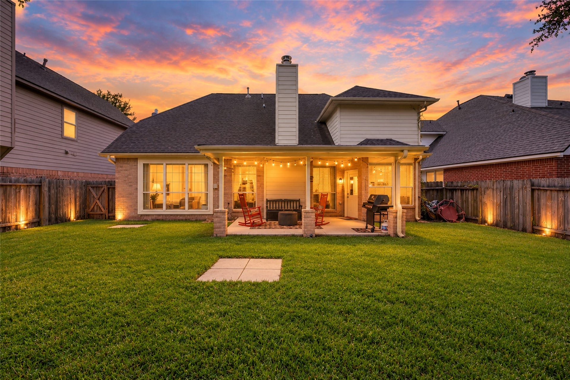 Covered backyard patio and spacious lawn create the perfect outdoor entertaining space.