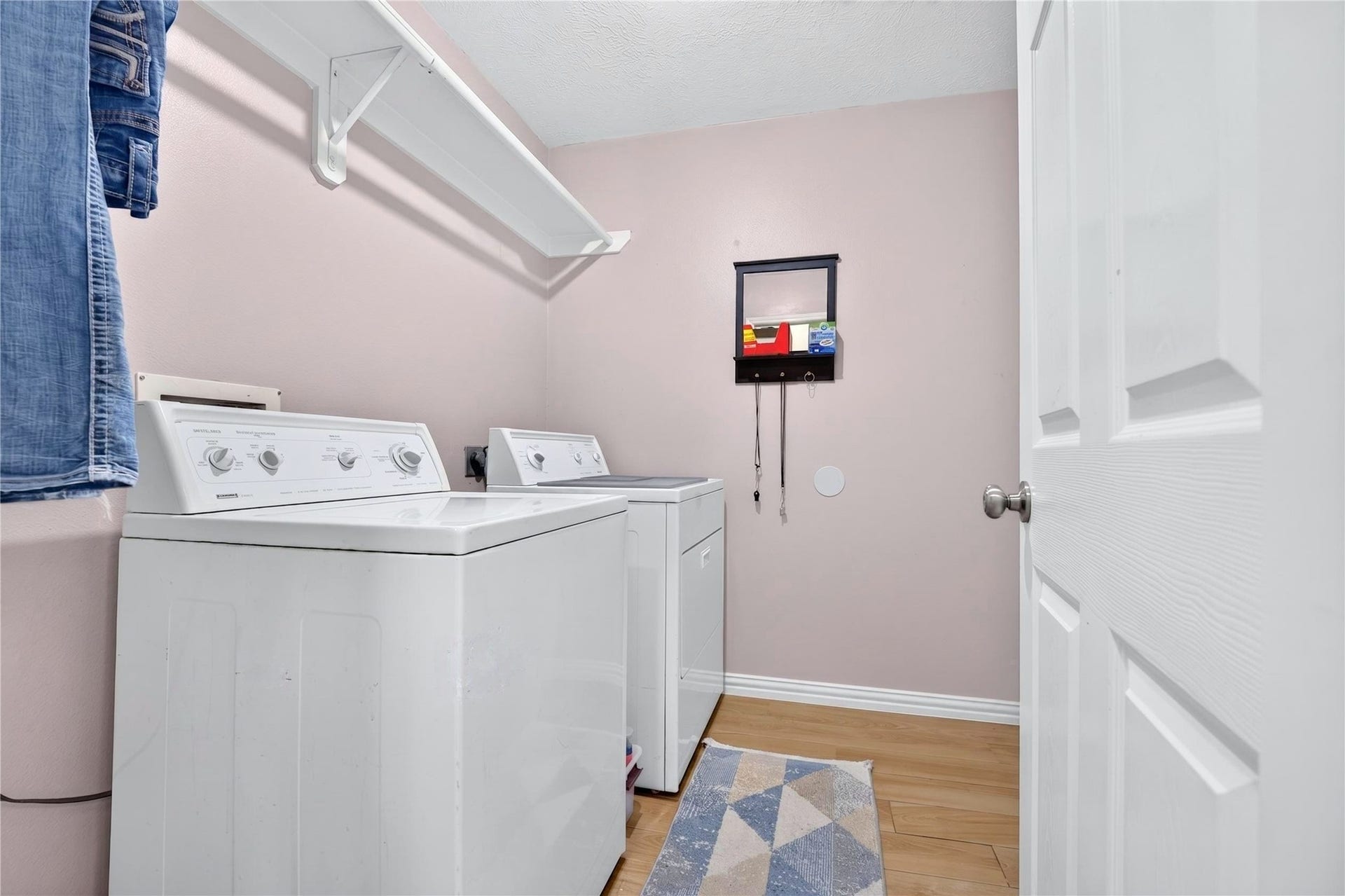 Dedicated indoor laundry room with shelving and storage space.
