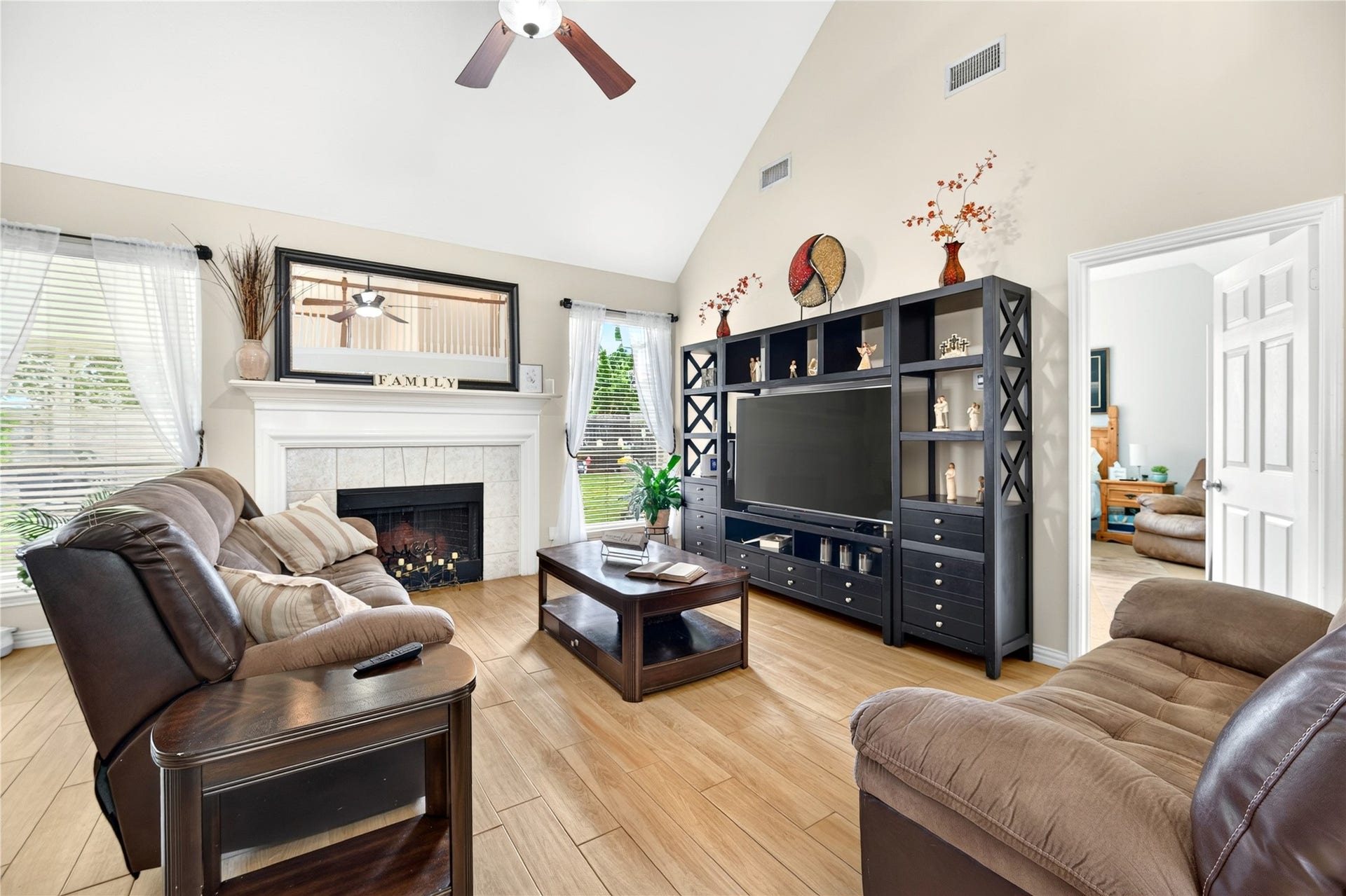 Spacious living room with soaring ceilings, abundant natural light and fireplace.