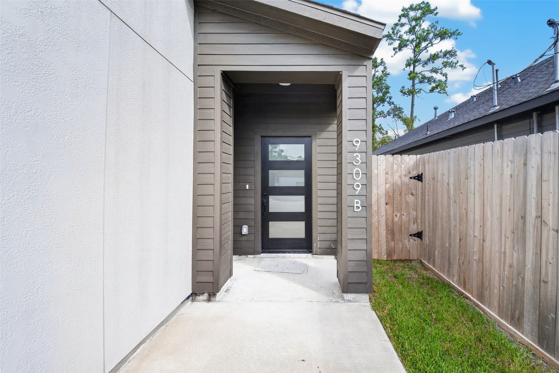 9309 Caddo Road, #B, Houston, TX 77078 Your private entrance awaits for Unit B. Tucked neatly behind a wood-fenced side path, this sleek glass-paneled entry offers a stylish, secluded retreat to welcome guests in total privacy.