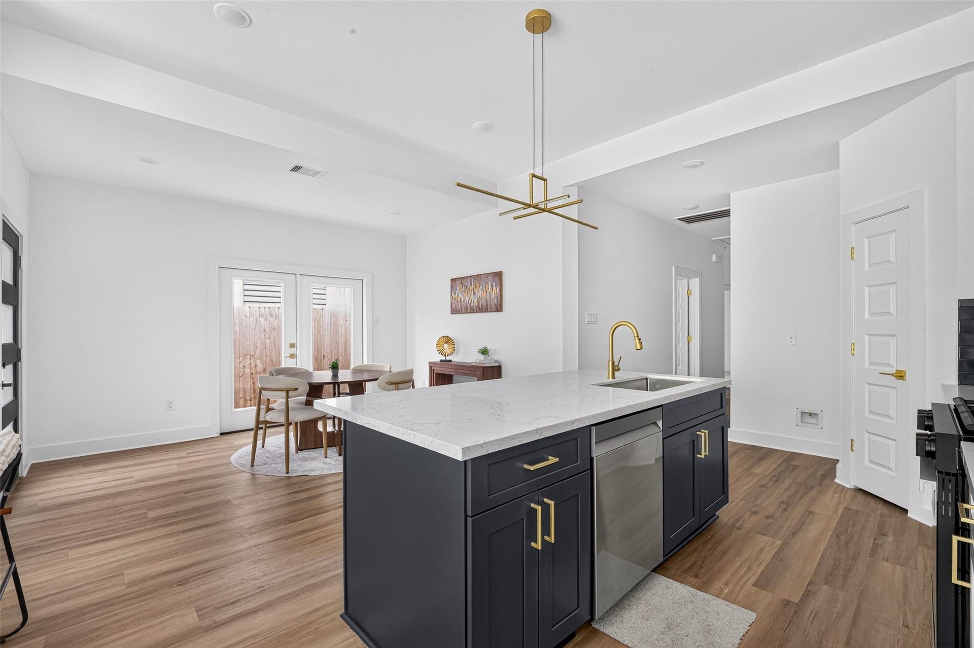 9309 Caddo Road, #B, Houston, TX 77078 Designed for seamless entertaining, the chef's kitchen features a central island, rich cabinetry, and warm wood-look floors that flow effortlessly into a sunlit dining nook. Large glass doors pull the outdoors in, creating an inviting backdrop for every meal.