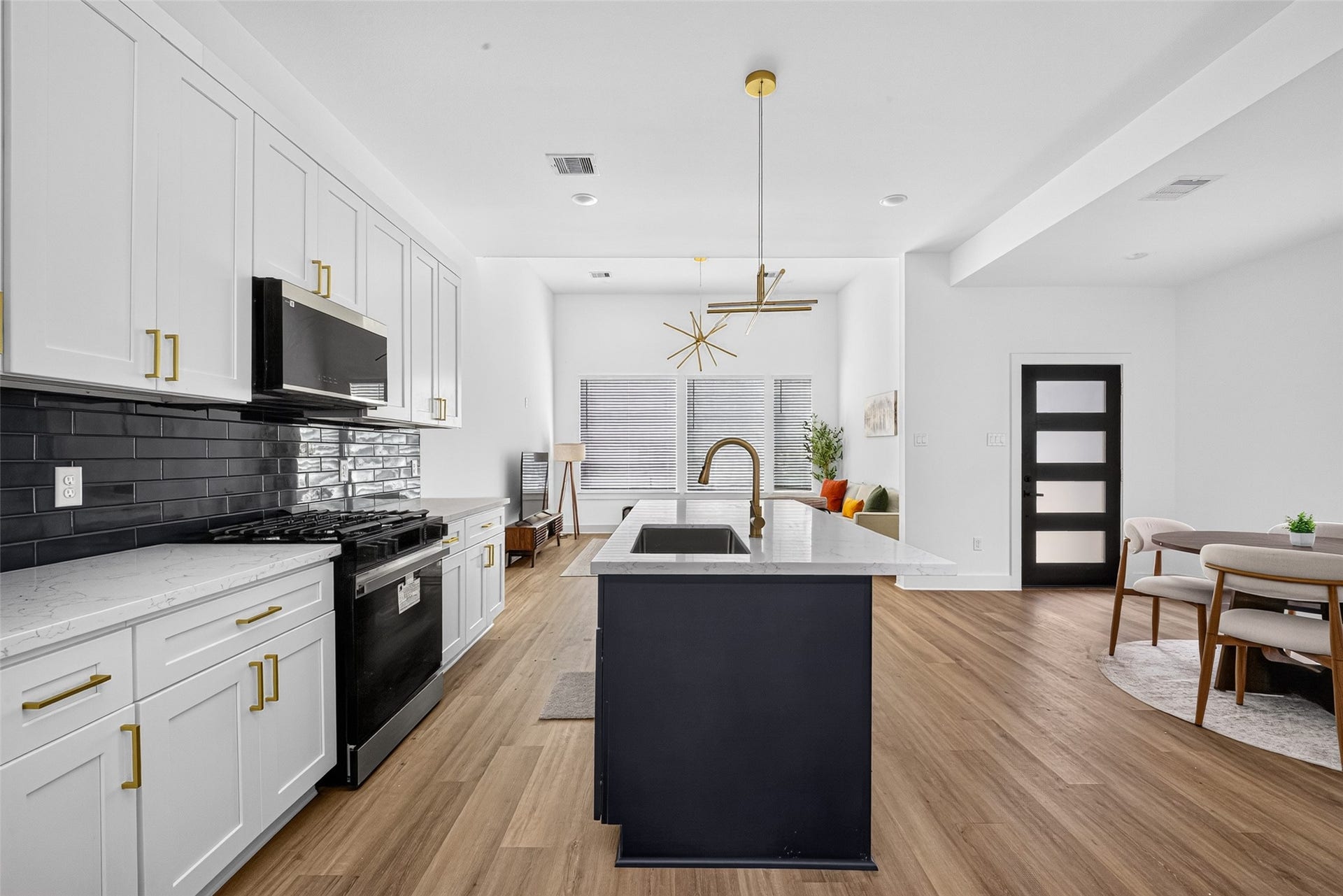 9309 Caddo Road, #B, Houston, TX 77078 Crisp white shaker cabinets contrast brilliantly against a bold, glossy navy subway tile backsplash, creating a kitchen that is equal parts modern and timeless.