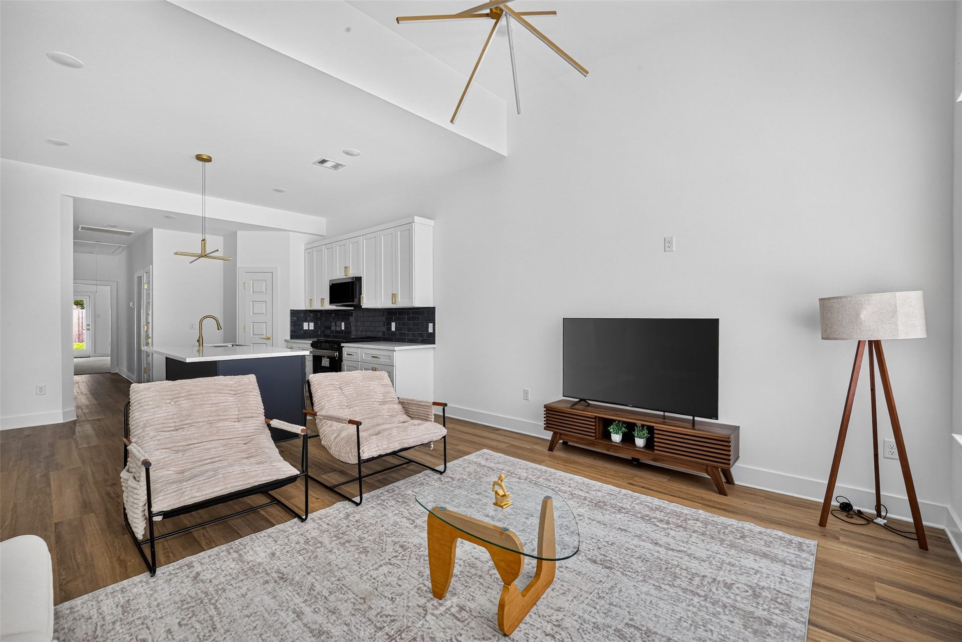 9309 Caddo Road, #B, Houston, TX 77078 High ceilings and custom geometric lighting elevate the room's spacious feel, offering the ideal layout for kicking back with a good book or lounging with friends.
