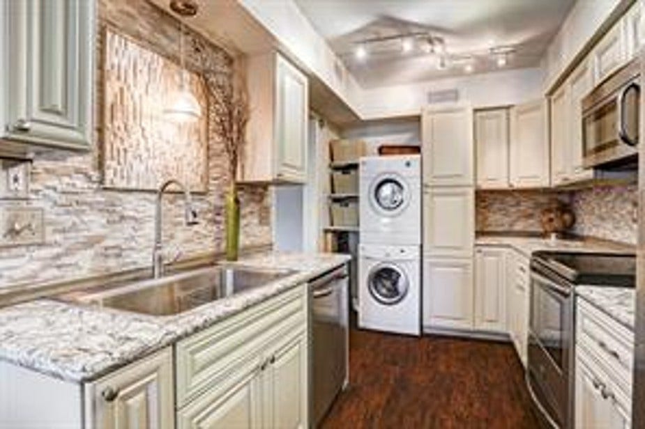 The space is well-lit with pendant and track lighting, and has a warm, inviting atmosphere with its wood flooring.