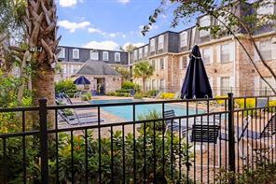 There are 2 courtyards with a swimming pools, surrounded by brick buildings and lush greenery. There are lounge chairs and umbrellas, to sit in nature and chat with neighbors. The setting is serene and well-maintained, ideal for enjoying the great outdoors.