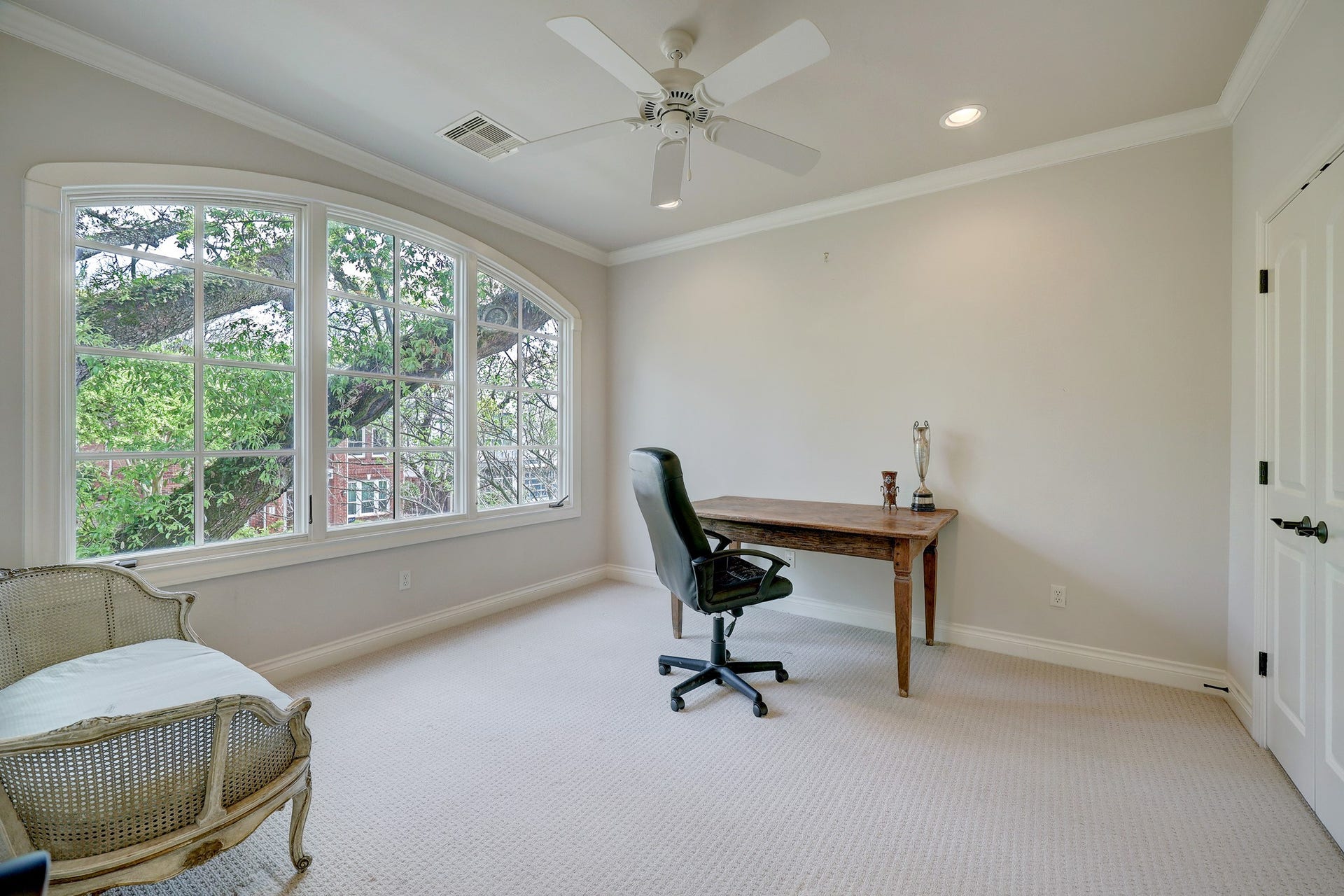 6004 Lake Street, Houston, TX 77005 Secondary bedroom at the front of the house featuring a large arched window with tree views