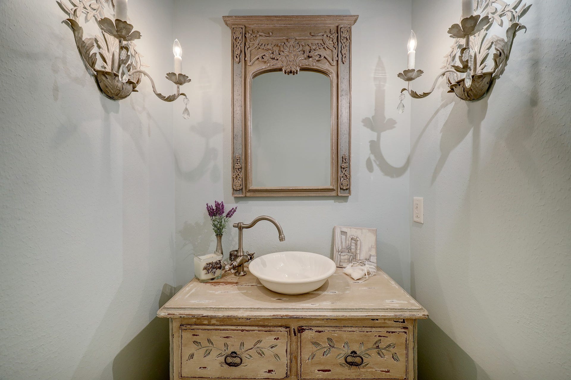 6004 Lake Street, Houston, TX 77005 Charming powder room with vintage-inspired fixtures, featuring an ornate mirror, elegant wall sconces, and a rustic vanity with a vessel sink.