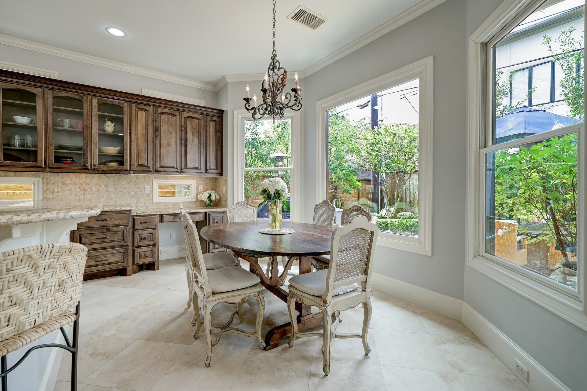 6004 Lake Street, Houston, TX 77005 Bright and inviting breakfast nook with large windows overlooking the back patio, featuring abundant storage with pretty wooden cabinetry.
