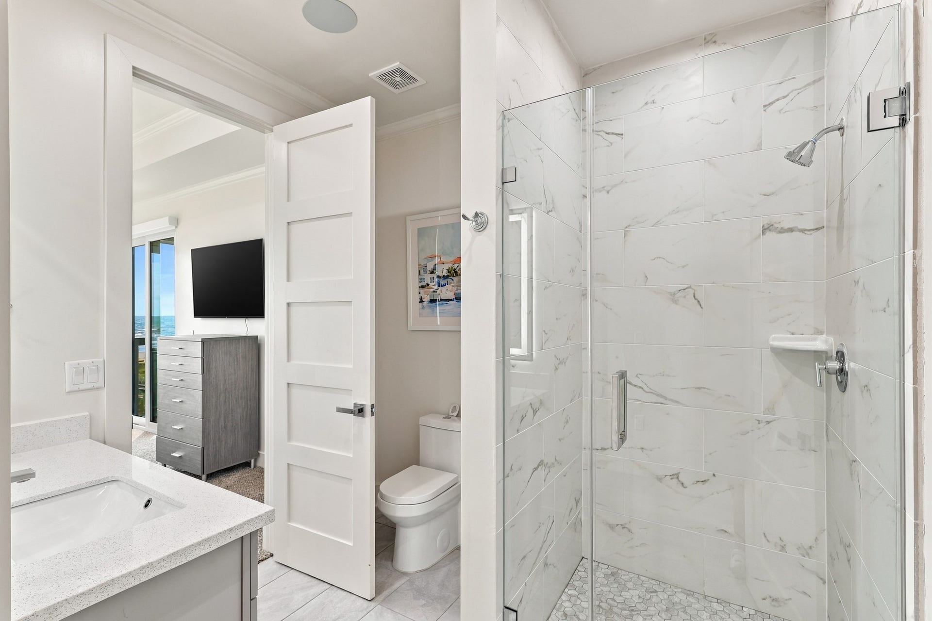 17211 Termini San Luis Pass Rd, Galveston, TX 77554 En suite bathroom
Contemporary en suite bathroom featuring a glass-enclosed walk-in shower, marble-look wall tile, and a mosaic shower floor. Direct bedroom access adds everyday convenience.