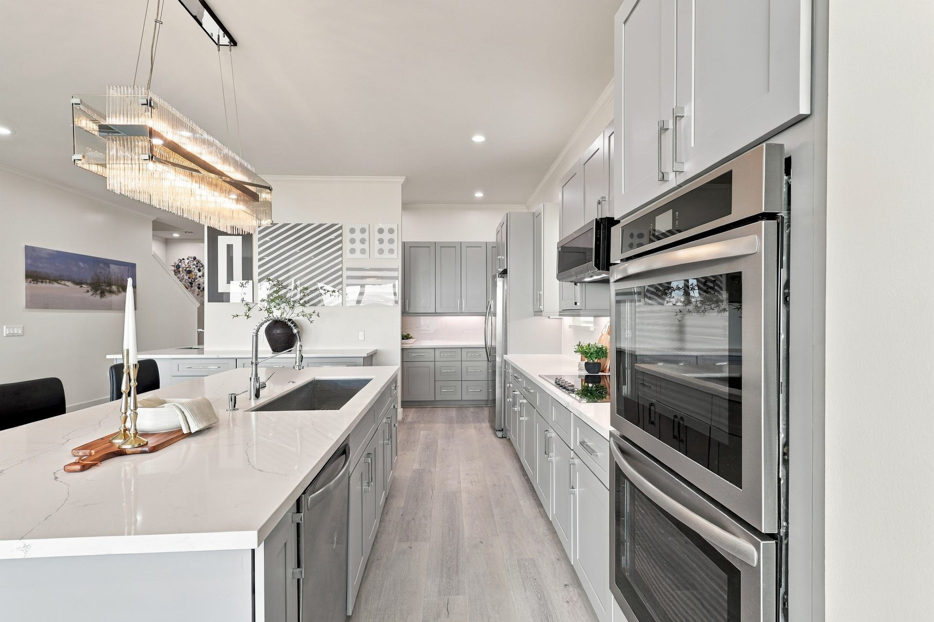 17211 Termini San Luis Pass Rd, Galveston, TX 77554 Double wall ovens, generous island workspace, and abundant cabinetry bring function to this elegant kitchen. Subtle countertop veining and a statement light fixture complete the polished look.