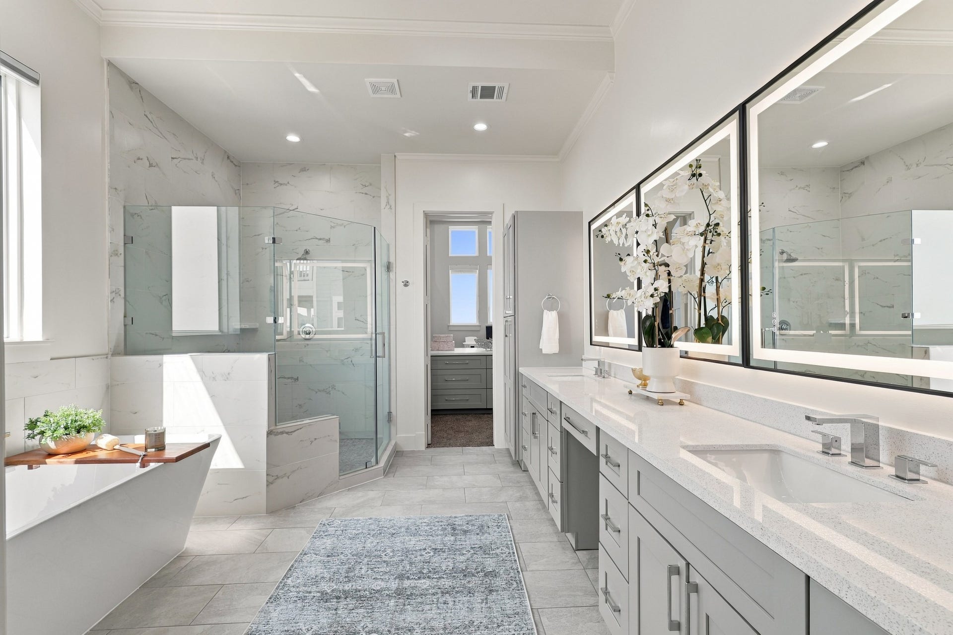 17211 Termini San Luis Pass Rd, Galveston, TX 77554 Primary bathroom
An expansive primary bathroom pairs a long dual-sink vanity with illuminated mirrors and generous cabinetry. A freestanding soaking tub and separate glass-enclosed shower create an elegant space to unwind.