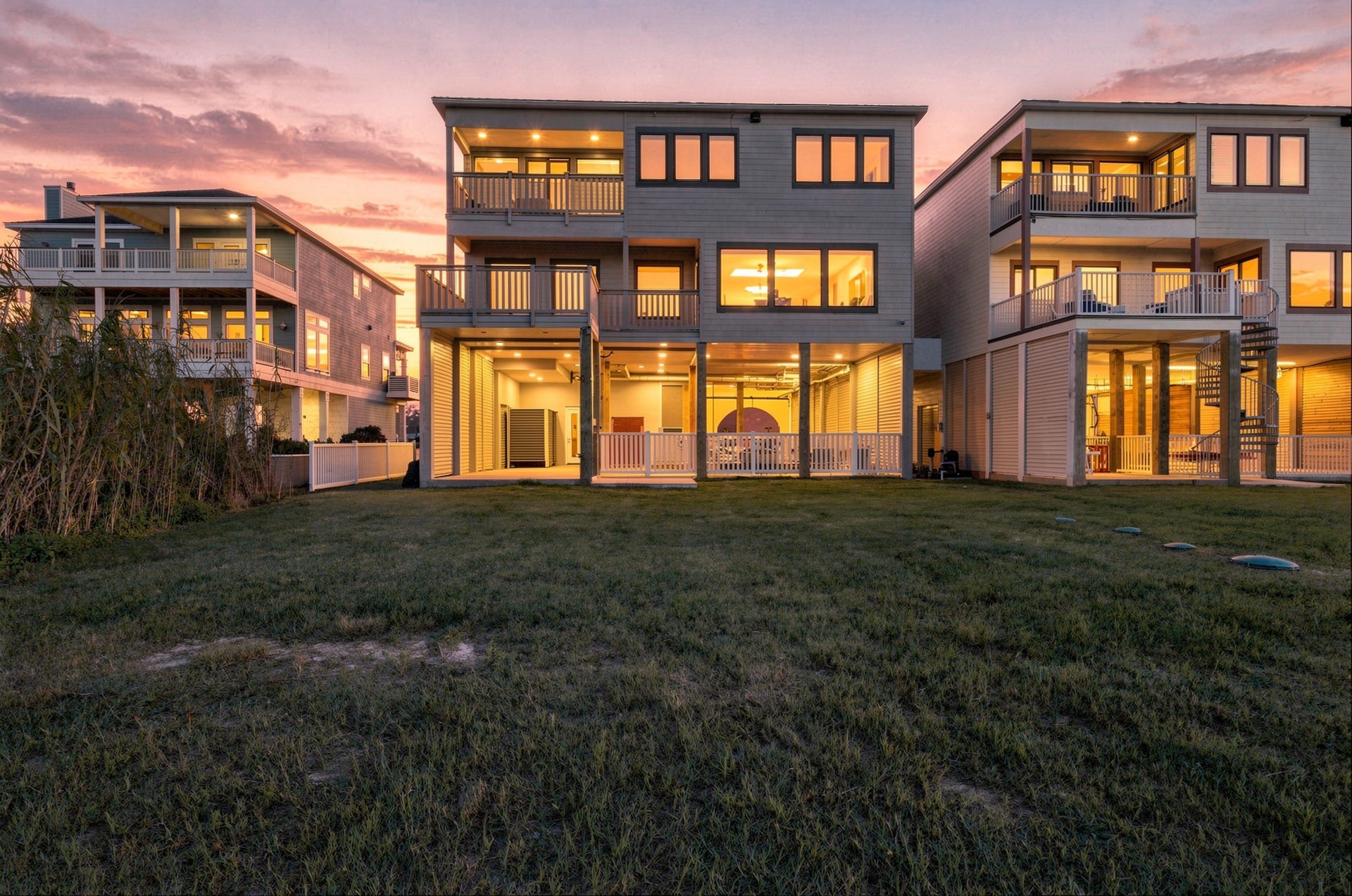 17211 Termini San Luis Pass Rd, Galveston, TX 77554 Beach-facing exterior at dusk
Warm evening lighting highlights the homes beach-facing elevation, covered balconies, and expansive windows. The lawn and sheltered ground-level spaces extend the opportunities for coastal outdoor living.