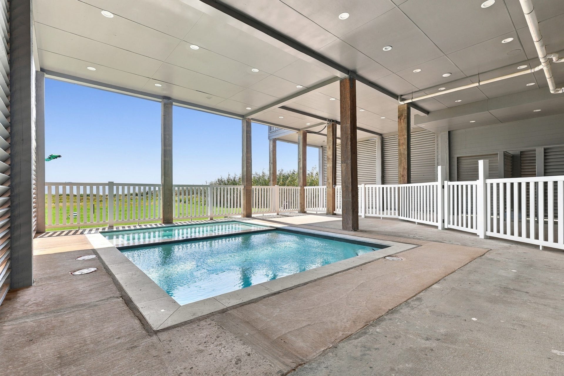 17211 Termini San Luis Pass Rd, Galveston, TX 77554 Pool area, alternate view
An alternate view showcases the pool and spa, surrounding deck space, and covered setting. White railings define the area while preserving views toward the coastal landscape.