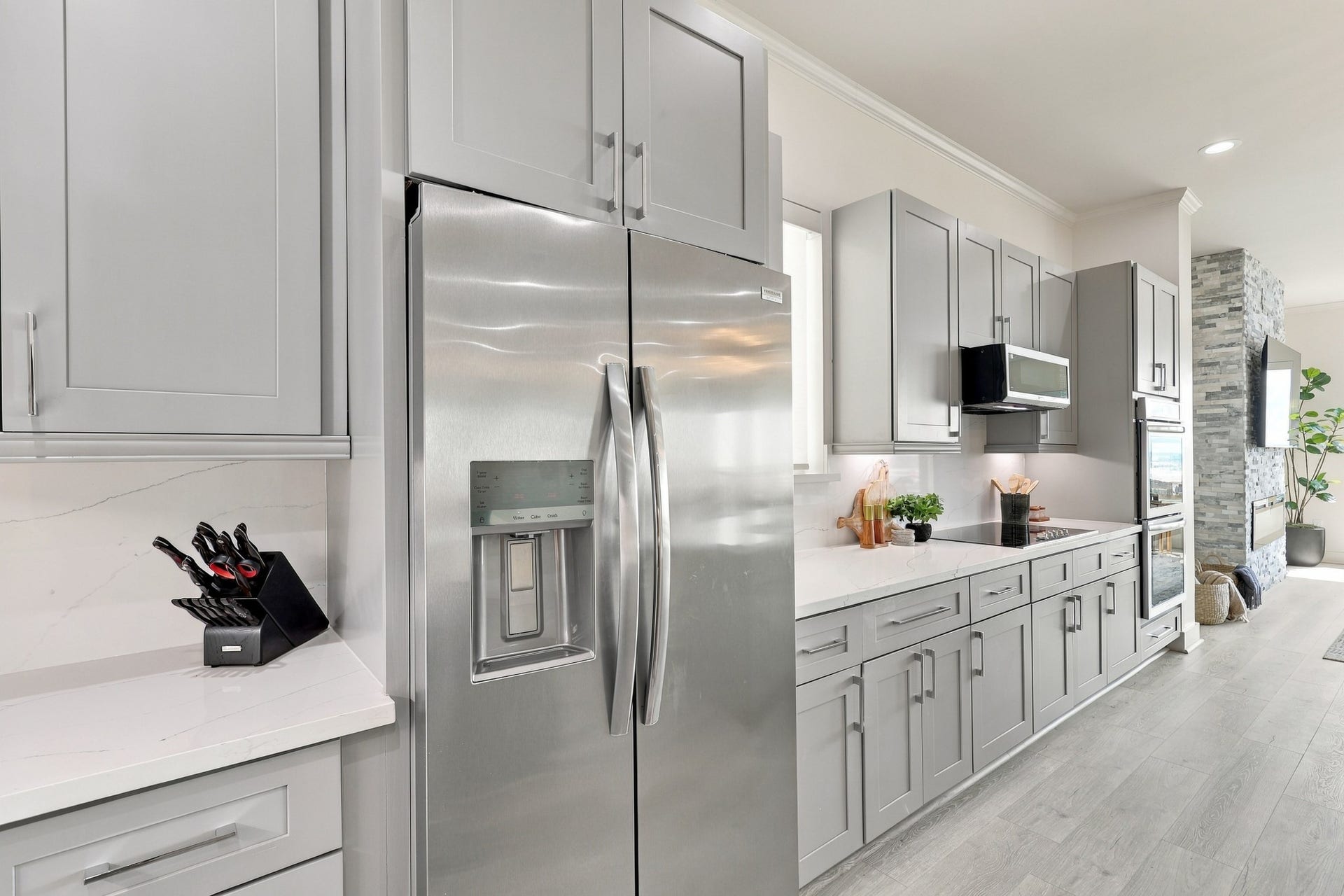17211 Termini San Luis Pass Rd, Galveston, TX 77554 Stainless steel appliances pair with gray cabinetry and a coordinating backsplash for a cohesive, contemporary finish. Under-cabinet lighting illuminates the extended preparation area.